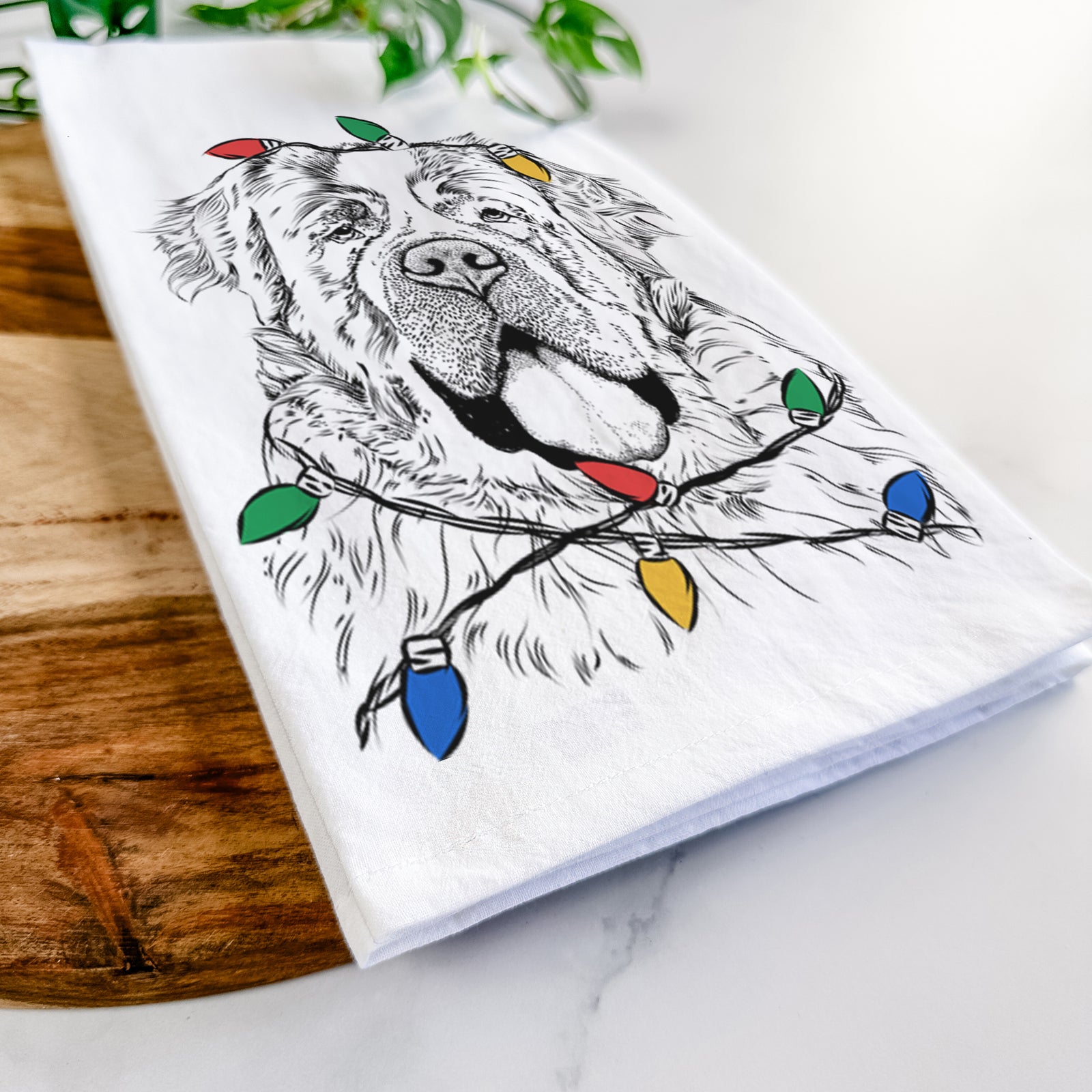 Hand-drawn sketch of Hoss the Saint Bernard wrapped in Christmas lights on a tea towel