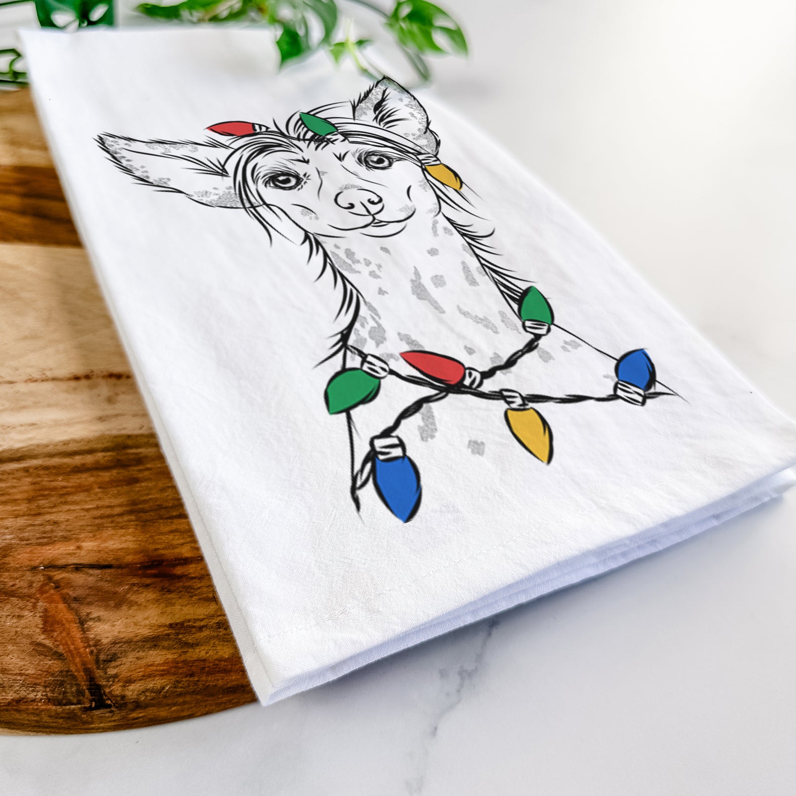 Hand-drawn sketch of Hudson the Chinese Crested wrapped in Christmas lights on a tea towel