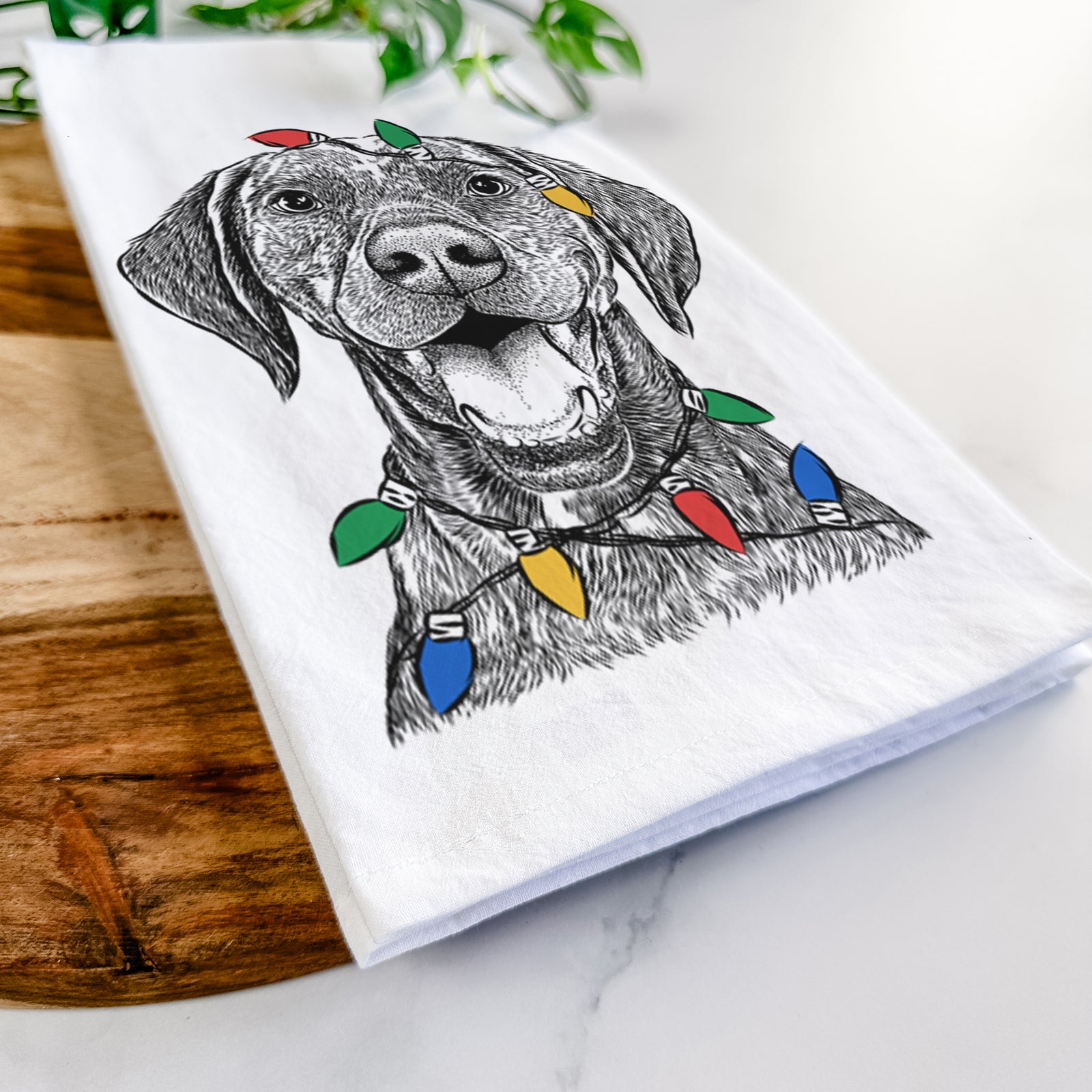 Hand-drawn sketch of Hudson the German Shorthaired Pointer wrapped in Christmas lights on a tea towel