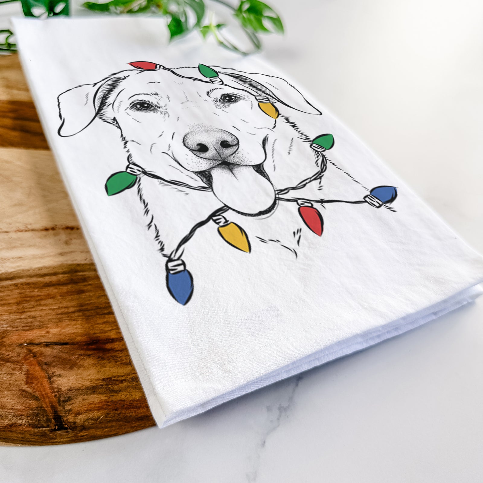 Hand-drawn sketch of Hudson the Shepherd wrapped in Christmas lights on a tea towel
