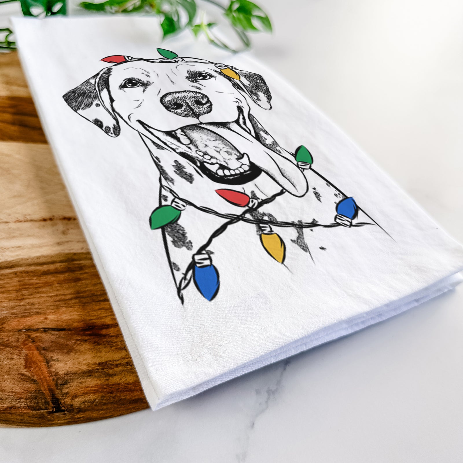 Hand-drawn sketch of Hydro the Dalmatian wrapped in Christmas lights on a tea towel