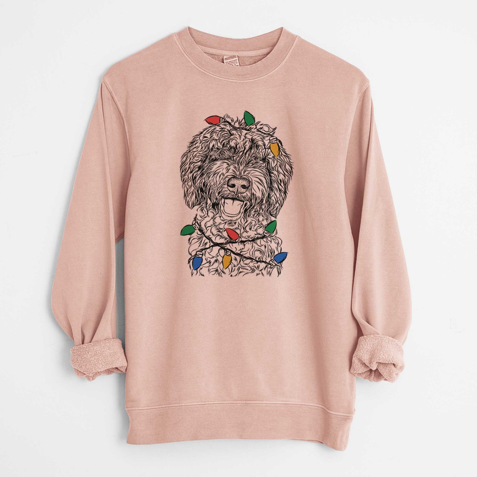 Hand-drawn sketch of Jack the Chocolate Labradoodle wrapped in Christmas lights on a Dusty Pink Unisex pigment dyed crew sweatshirt
