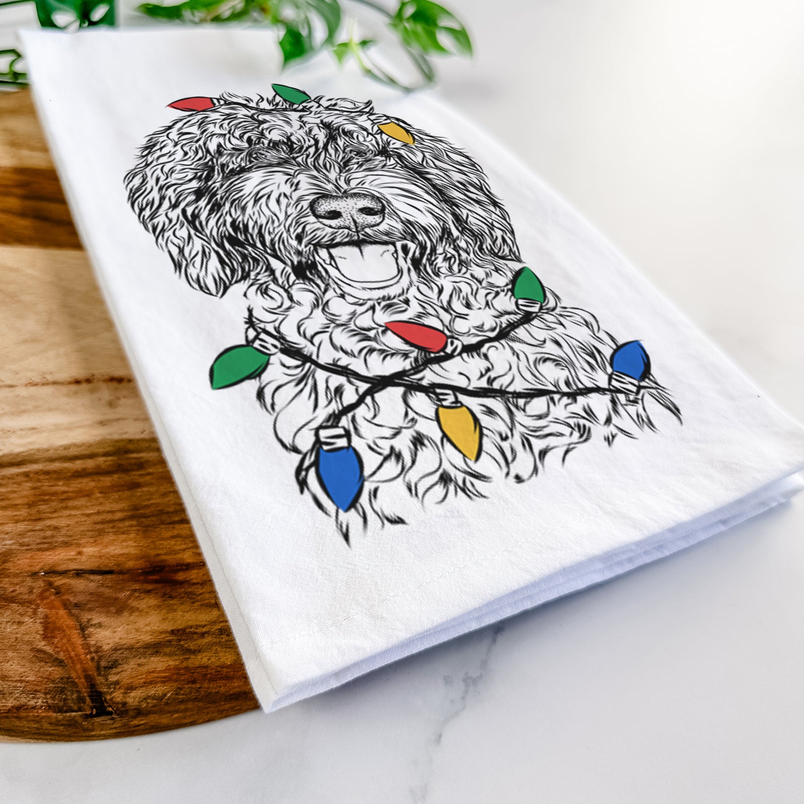 Hand-drawn sketch of Jack the Chocolate Labradoodle wrapped in Christmas lights on a tea towel