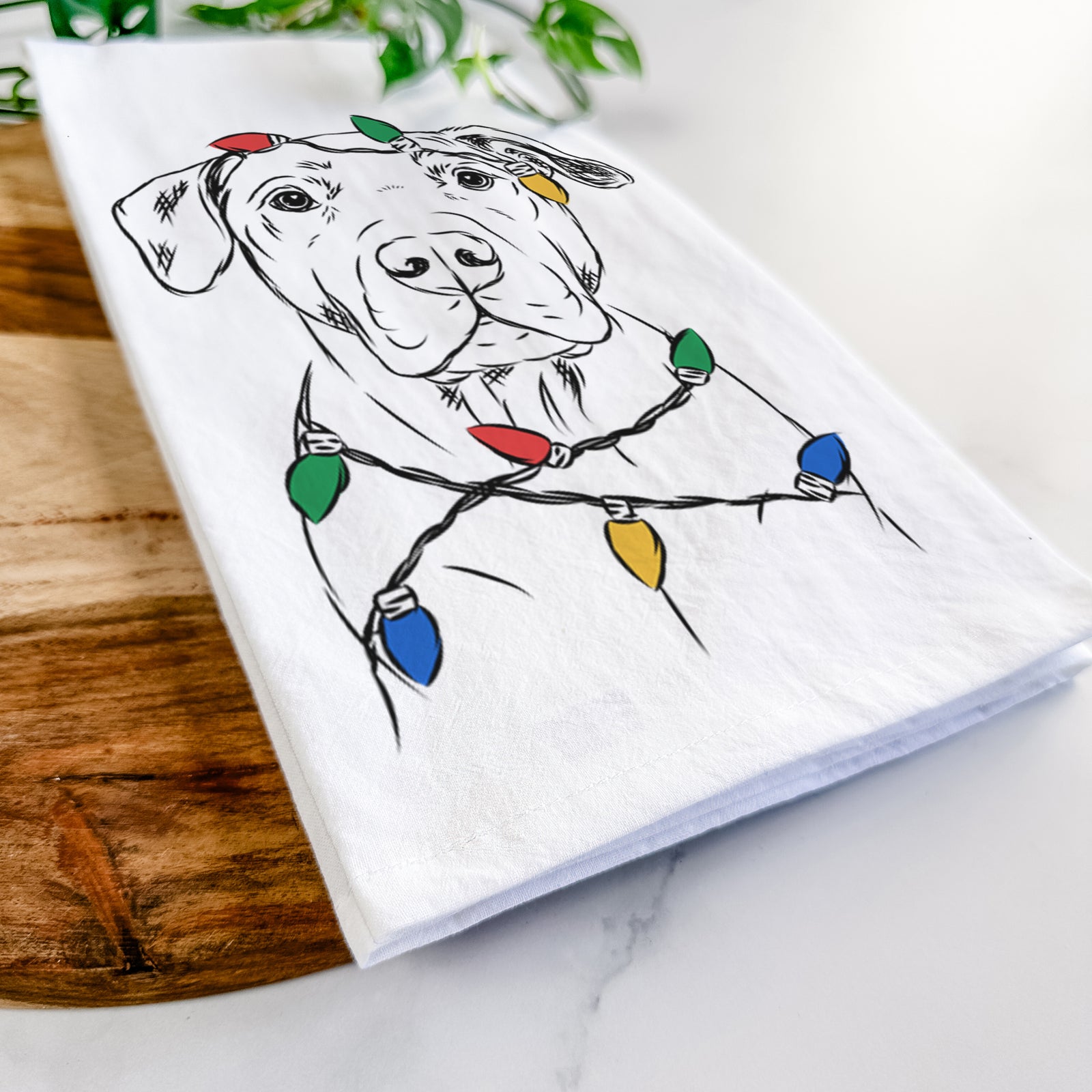 Hand-drawn sketch of Kadin the Pitbull wrapped in Christmas lights on a tea towel