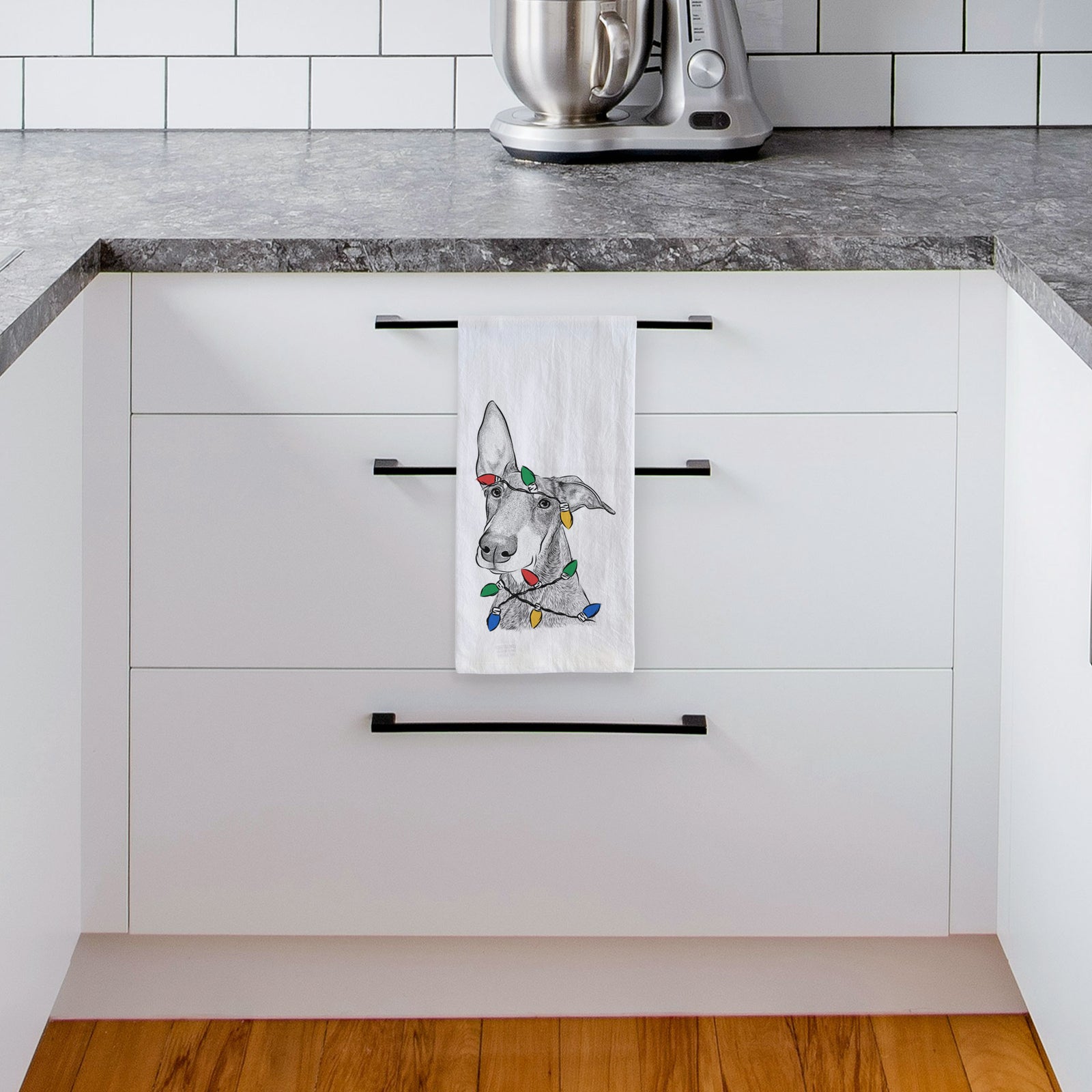 Hand-drawn sketch of Kain the Doberman Pinscher wrapped in Christmas lights on a tea towel, hanging on an oven door in a kitchen
