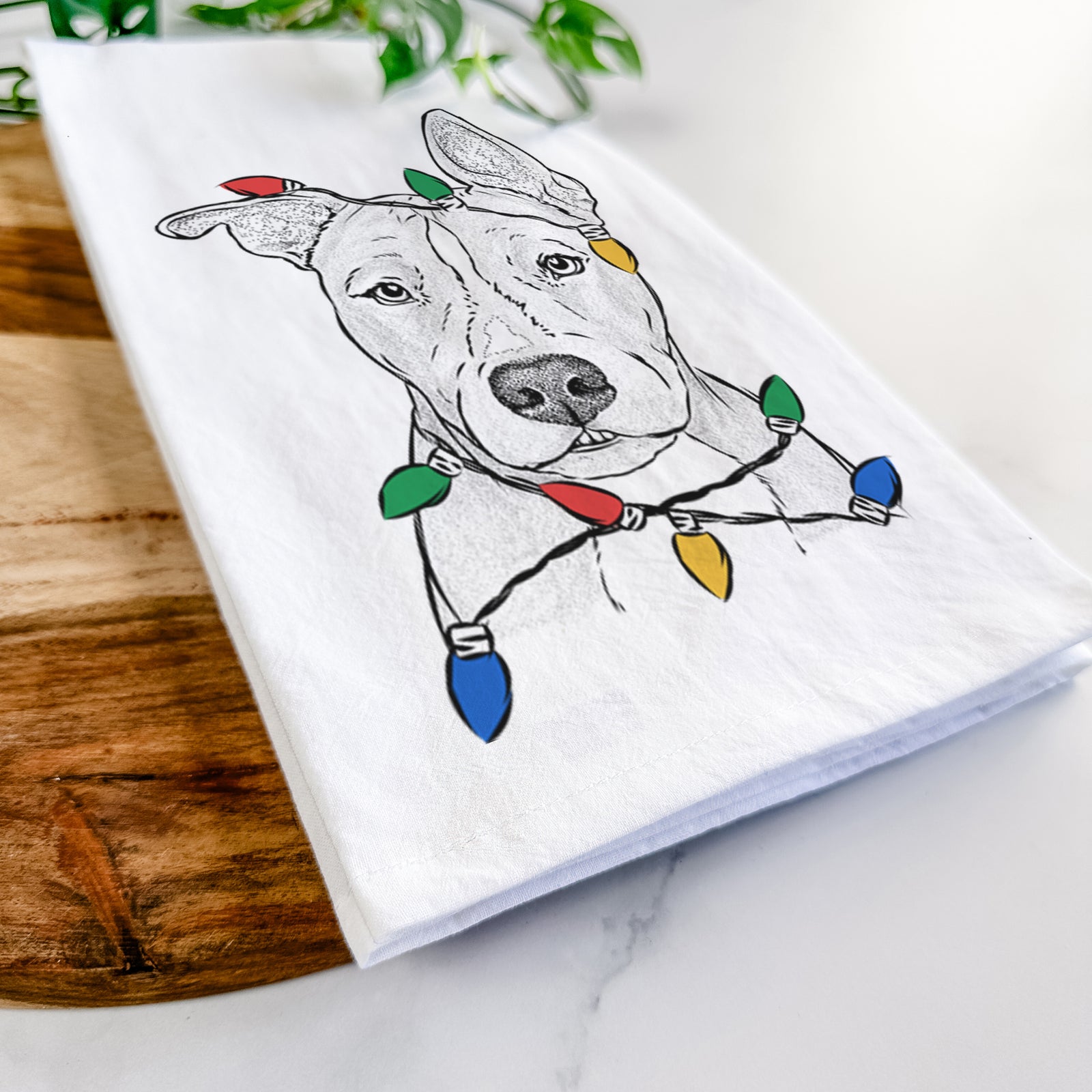 Hand-drawn sketch of Kisses the Pitbull wrapped in Christmas lights on a tea towel