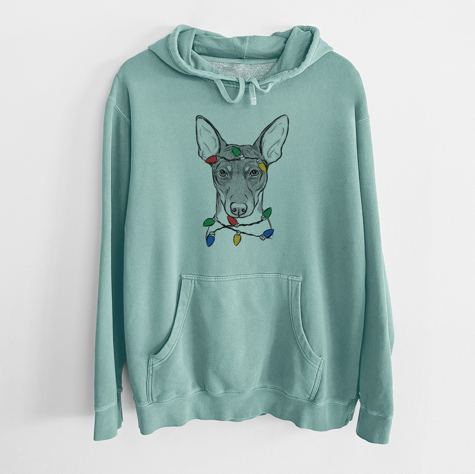 Hand-drawn sketch of Knox the Rat Terrier wrapped in Christmas lights on a Mint Unisex pigment dyed hoodie