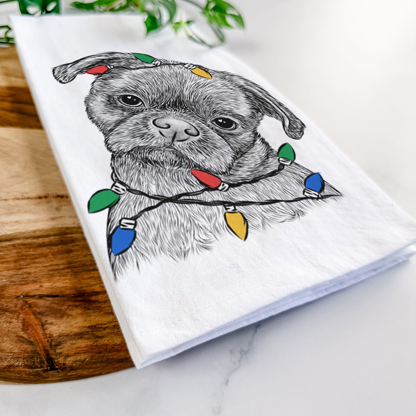 Hand-drawn sketch of Koko the Shih Tzu wrapped in Christmas lights on a tea towel