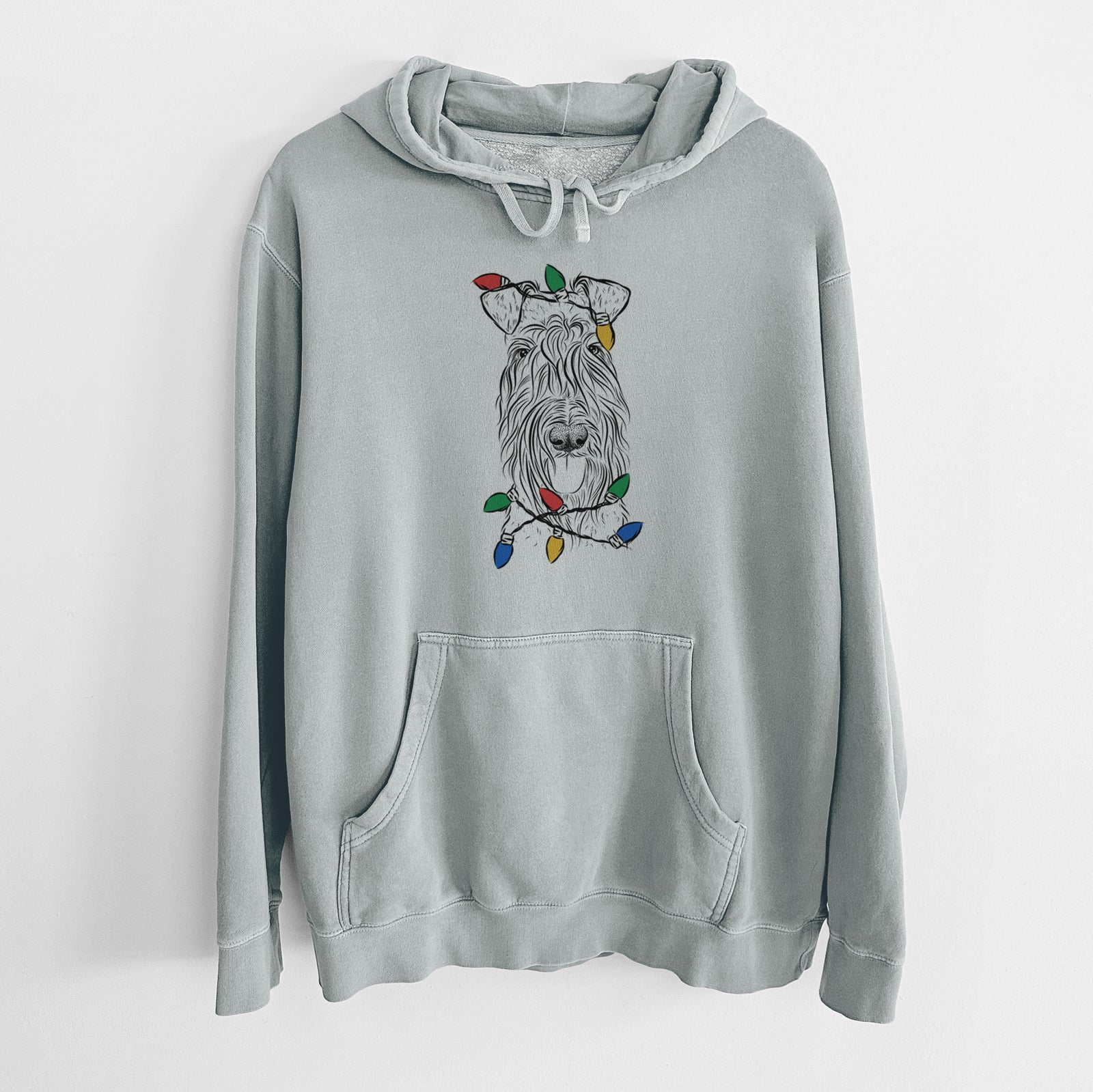 Hand-drawn sketch of Kricket the Kerry Blue Terrier wrapped in Christmas lights on a Sage Unisex pigment dyed hoodie