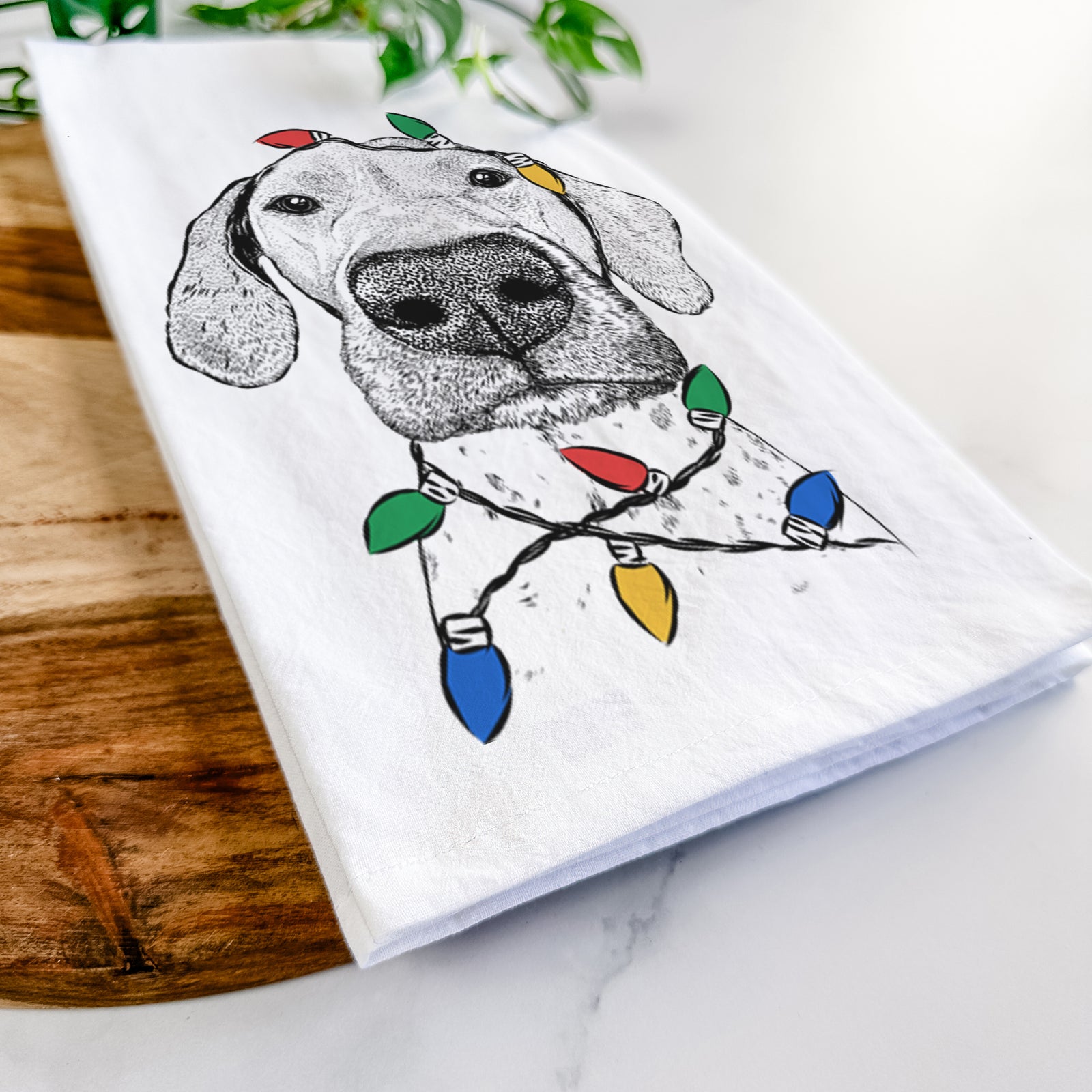 Hand-drawn sketch of Leroy the German Shorthaired Pointer wrapped in Christmas lights on a tea towel