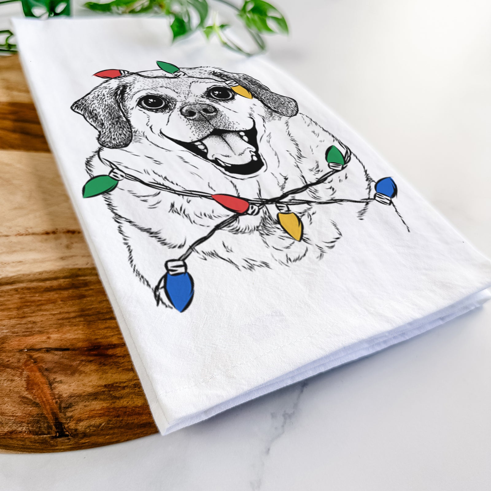 Hand-drawn sketch of Little Man the Puggle wrapped in Christmas lights on a tea towel