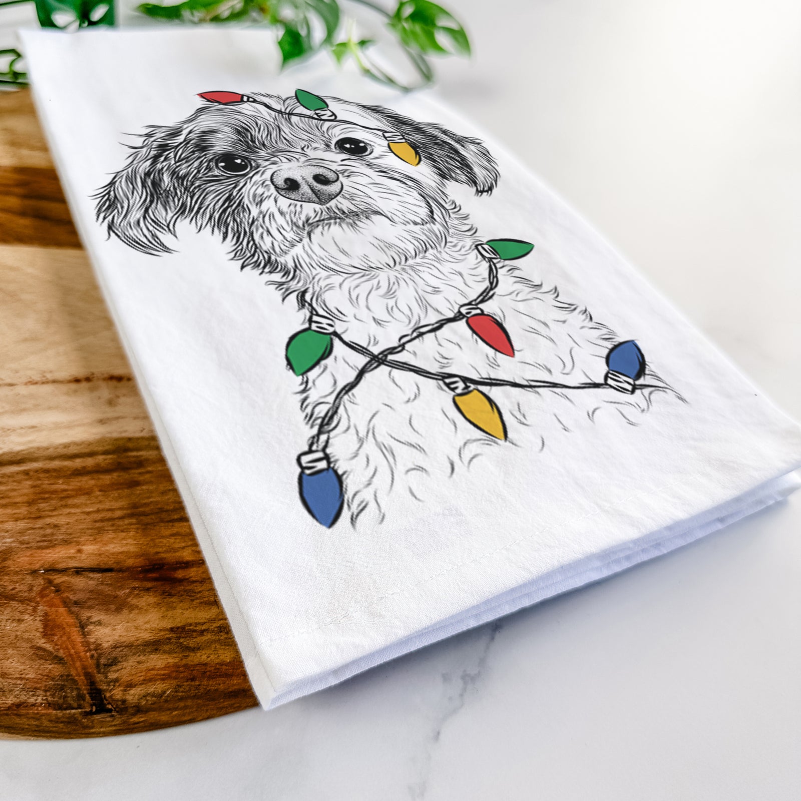 Hand-drawn sketch of Louise the Havanese wrapped in Christmas lights on a tea towel