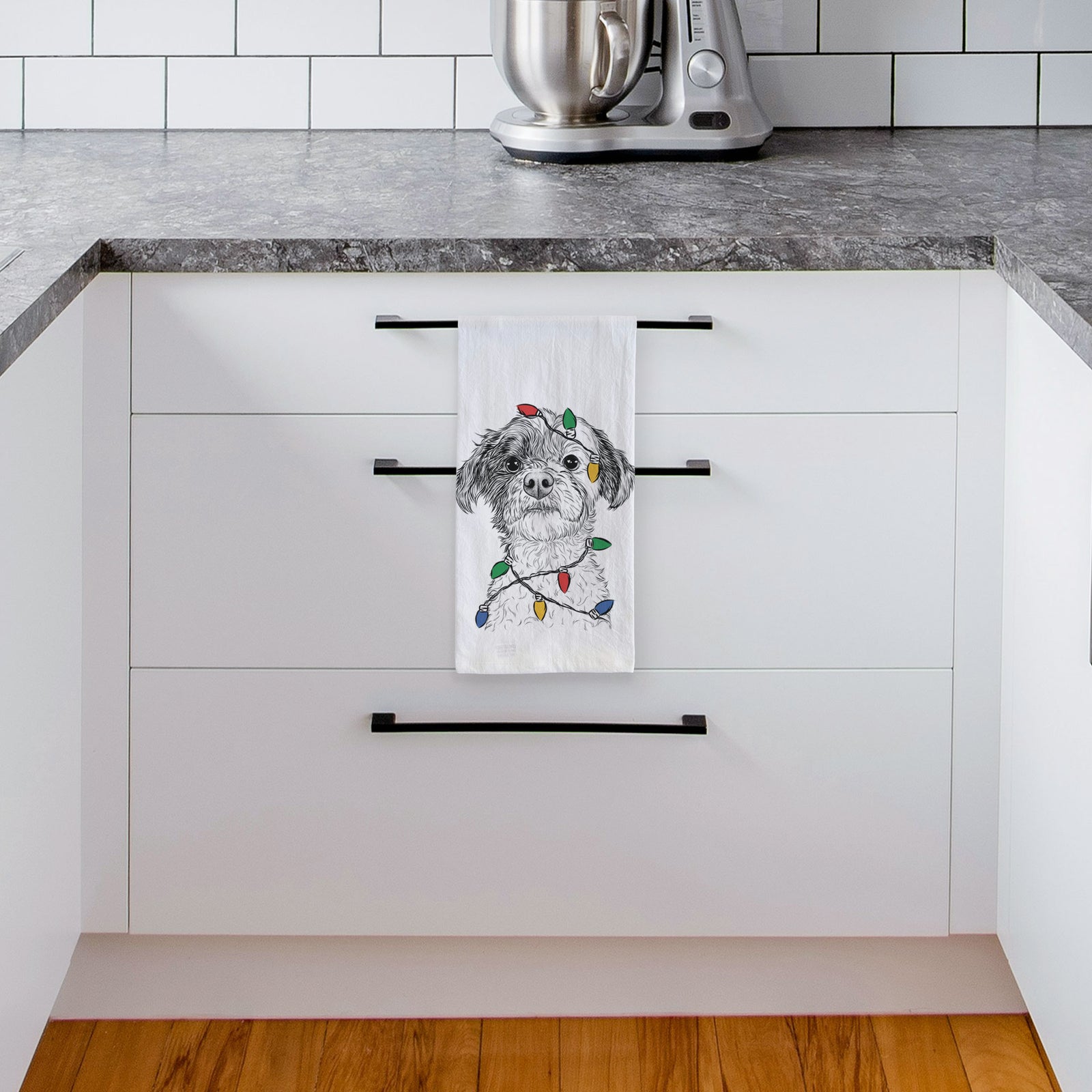 Hand-drawn sketch of Louise the Havanese wrapped in Christmas lights on a tea towel, hanging on an oven door in a kitchen