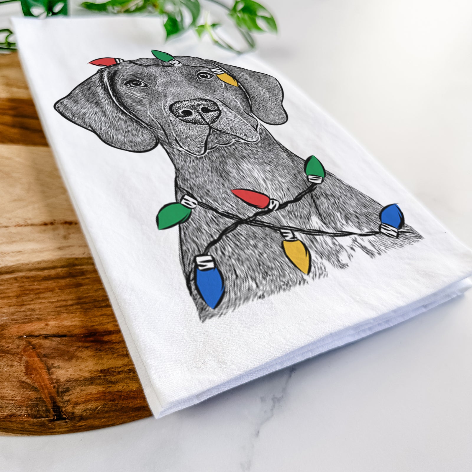 Hand-drawn sketch of Lucifer the German Shorthaired Pointer wrapped in Christmas lights on a tea towel
