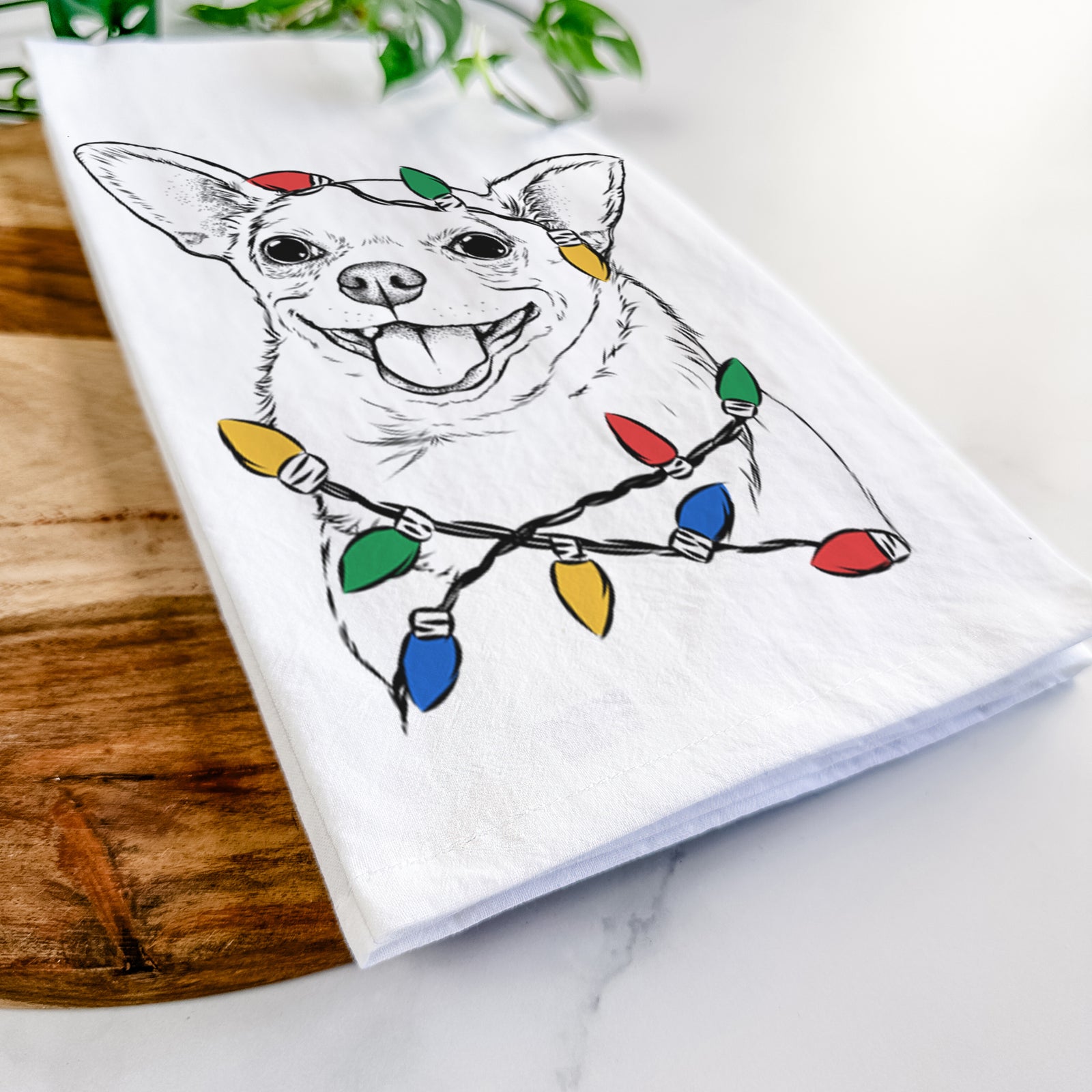 Hand-drawn sketch of Maddison Pearl the Chihuahua wrapped in Christmas lights on a tea towel