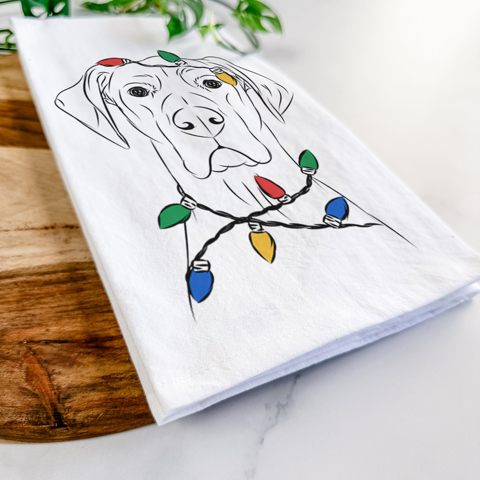 Hand-drawn sketch of Maddox the Great Dane wrapped in Christmas lights on a tea towel