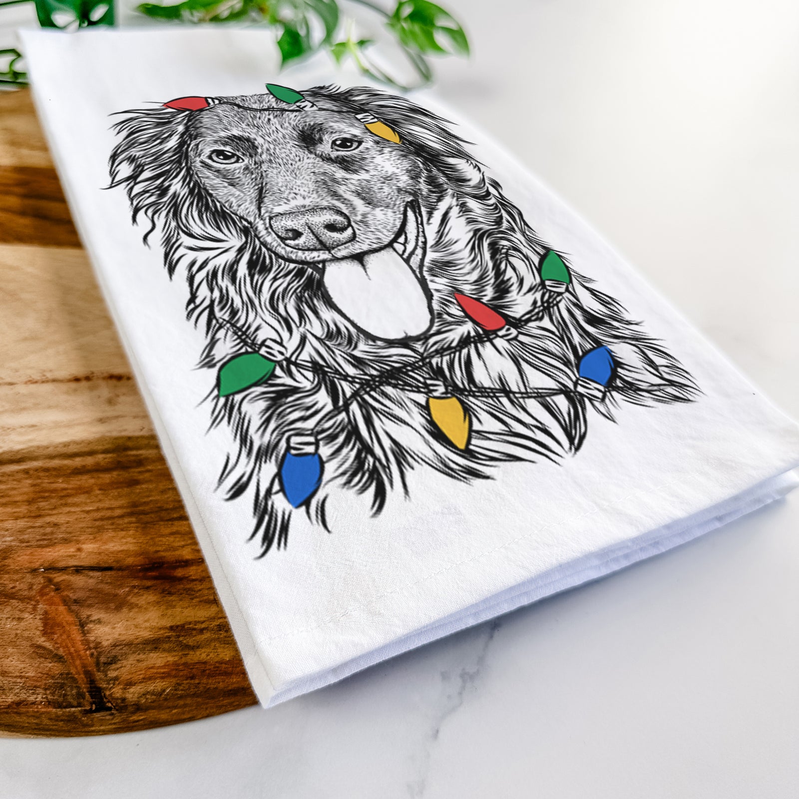 Hand-drawn sketch of Maisie Mae the Aussiedor wrapped in Christmas lights on a tea towel