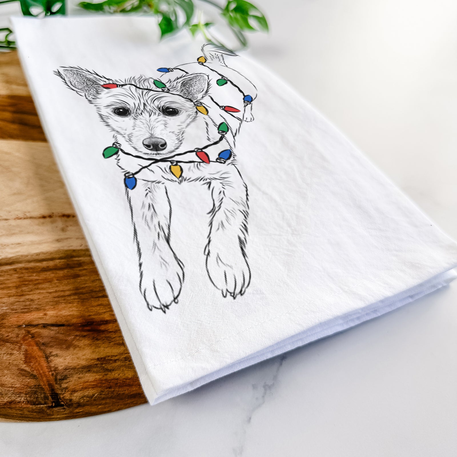 Hand-drawn sketch of Maisie the Terrier Mix wrapped in Christmas lights on a tea towel