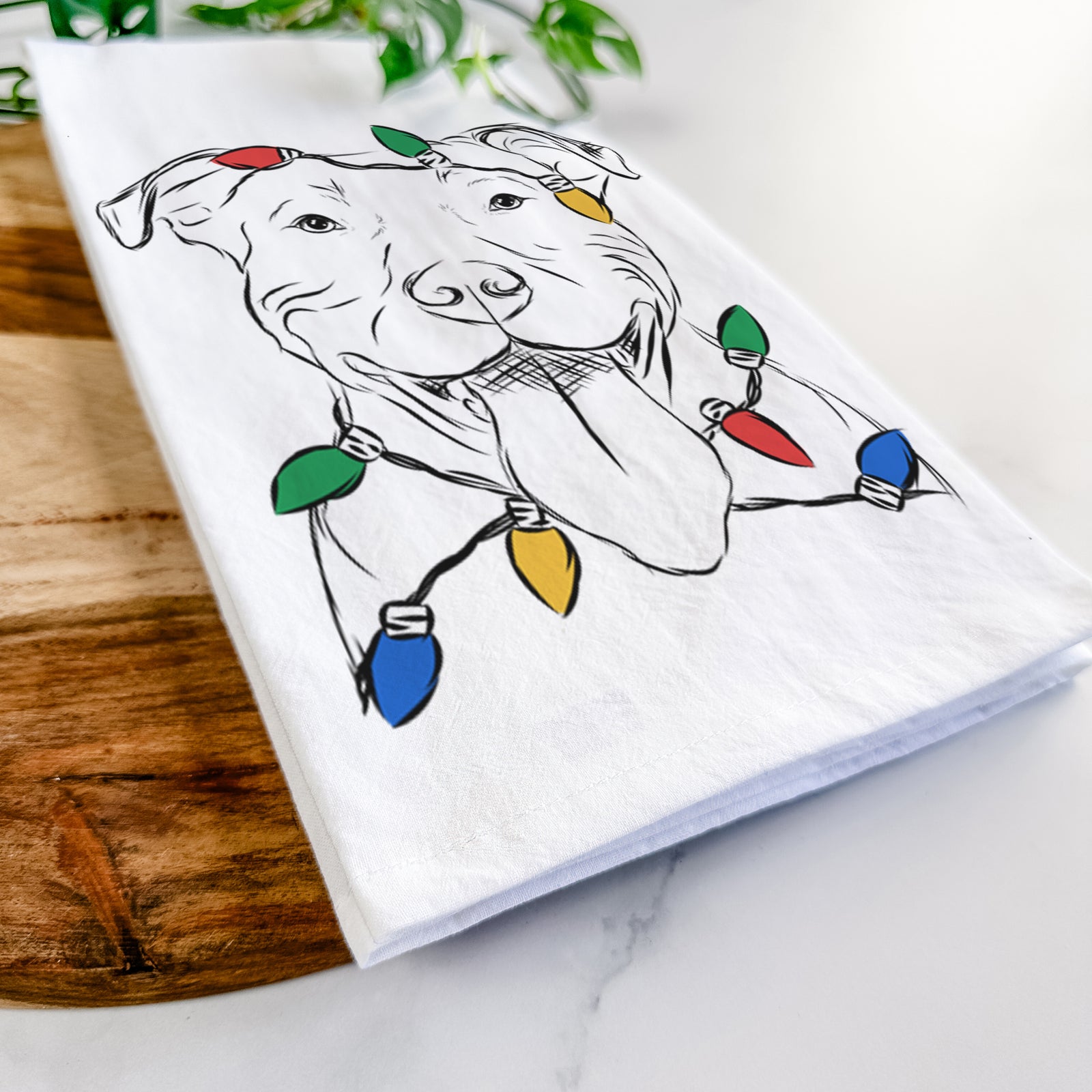 Hand-drawn sketch of Major the Pitbull wrapped in Christmas lights on a tea towel