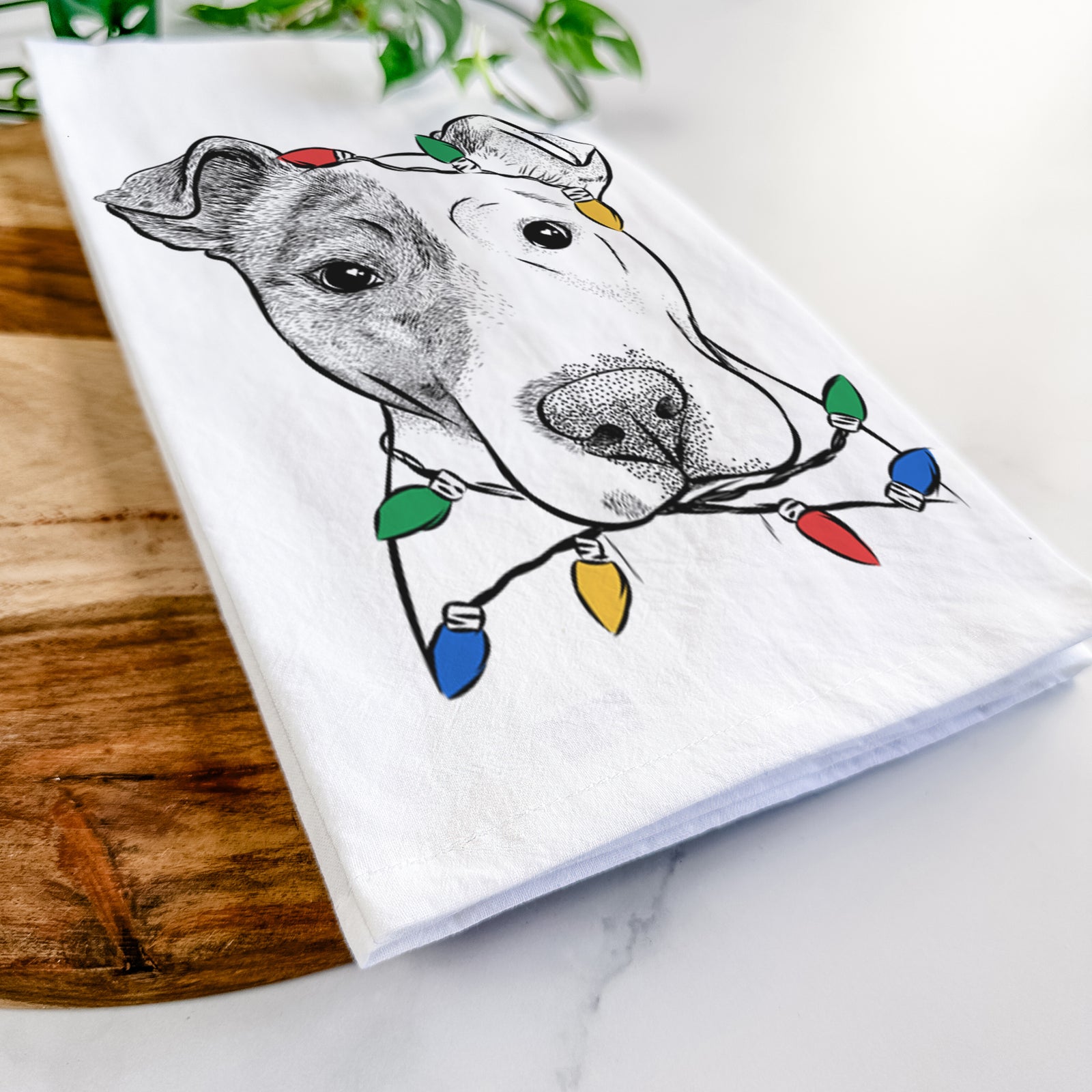 Hand-drawn sketch of Manchi the Pitbull Mix wrapped in Christmas lights on a tea towel