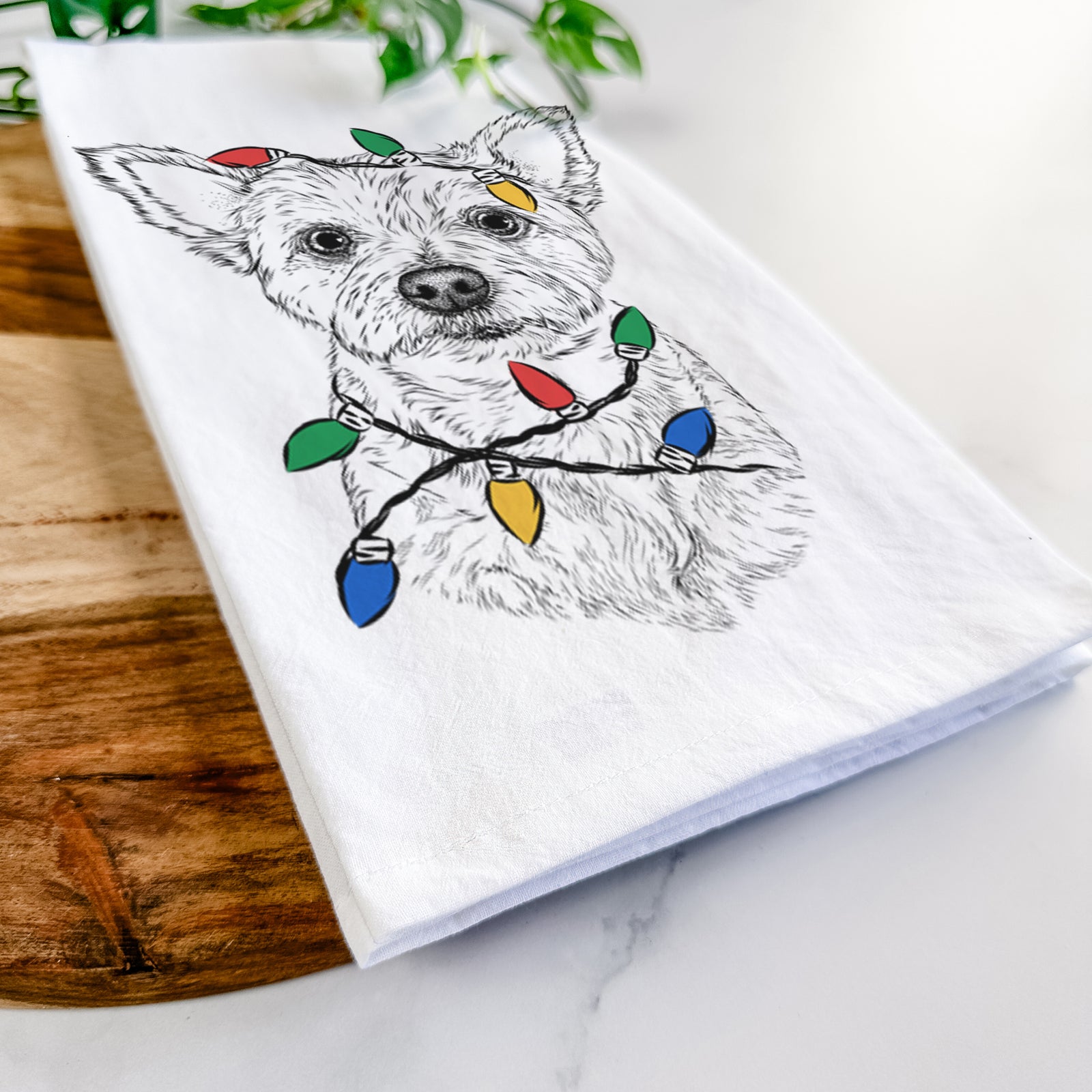 Hand-drawn sketch of Mango the Yorker Cairn Terrier Mix wrapped in Christmas lights on a tea towel
