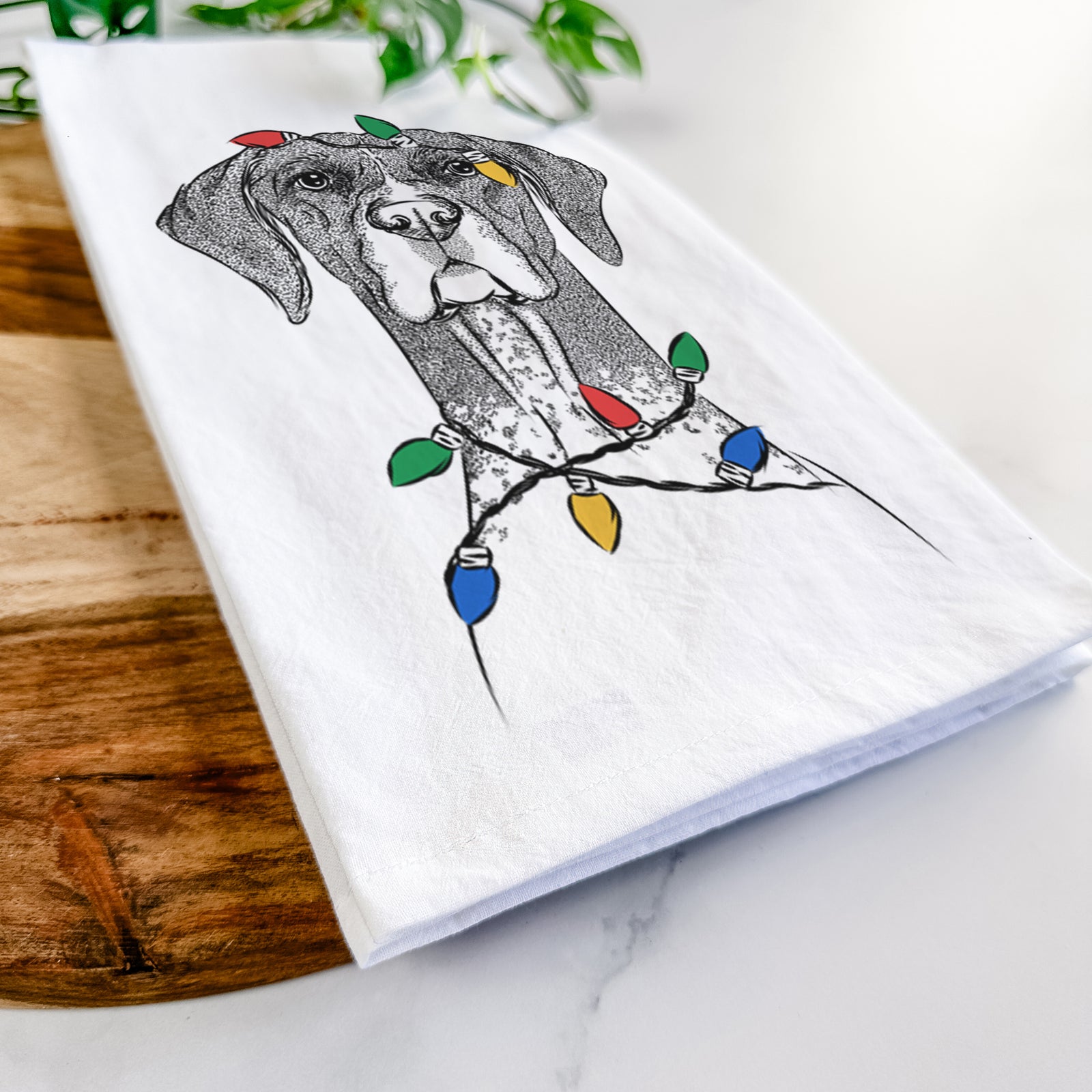 Hand-drawn sketch of Mattis the German Shorthaired Pointer wrapped in Christmas lights on a tea towel
