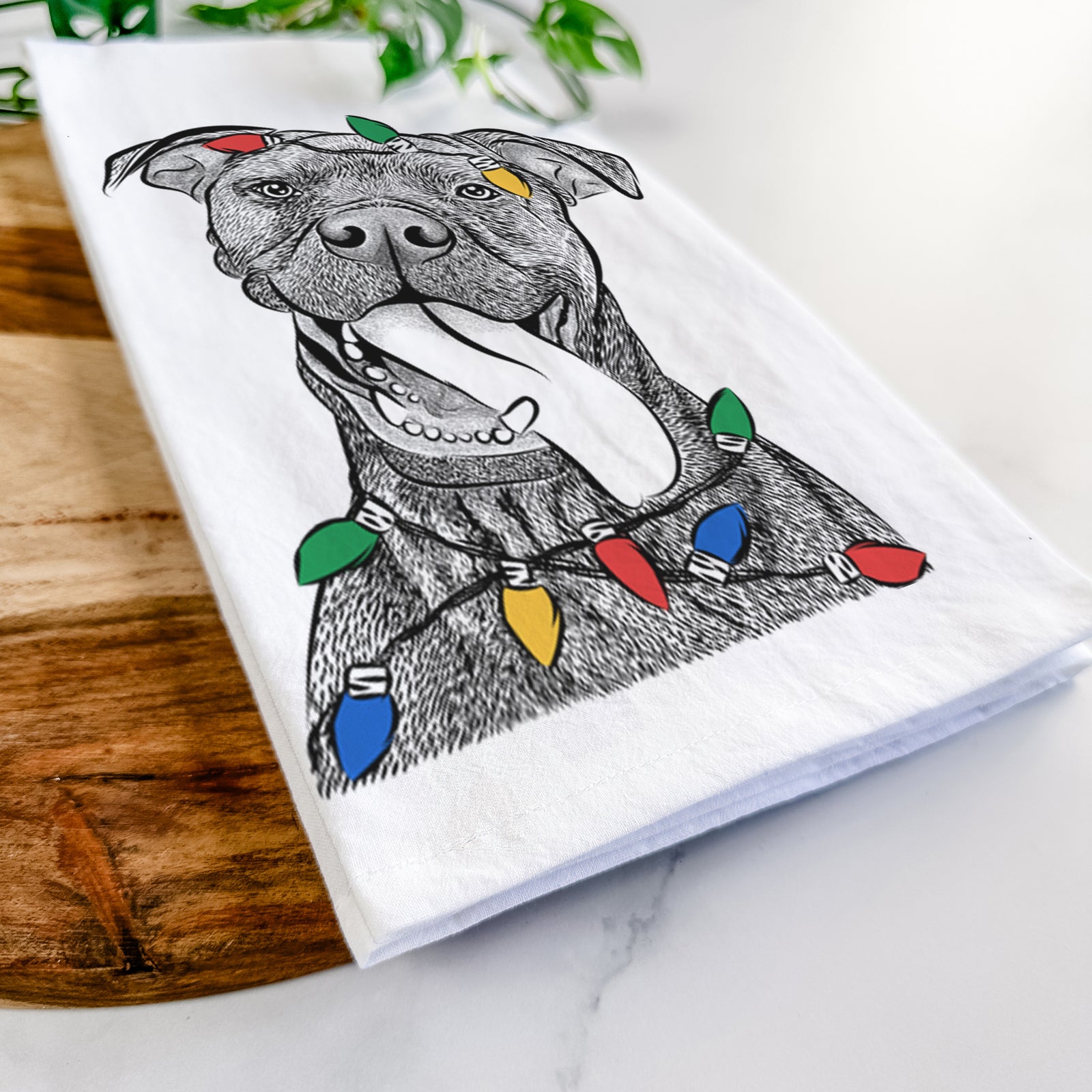 Hand-drawn sketch of Mikey the Boxador wrapped in Christmas lights on a tea towel
