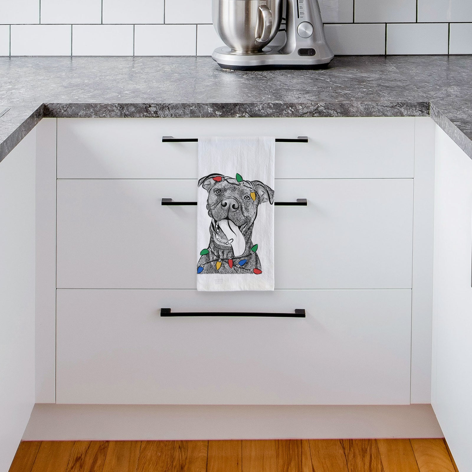 Hand-drawn sketch of Mikey the Boxador wrapped in Christmas lights on a tea towel, hanging on an oven door in a kitchen