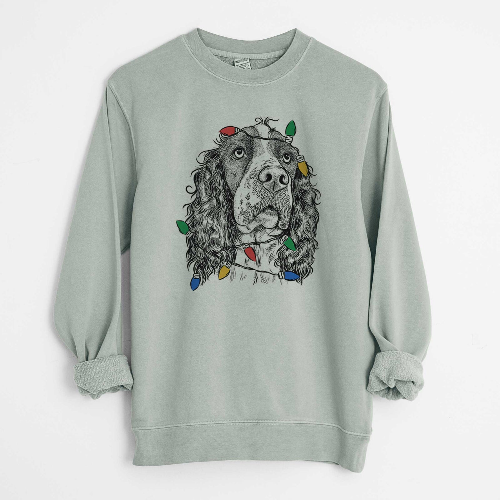 Hand-drawn sketch of Millie Mae the English Springer Spaniel wrapped in Christmas lights on a Sage Unisex pigment dyed crew sweatshirt