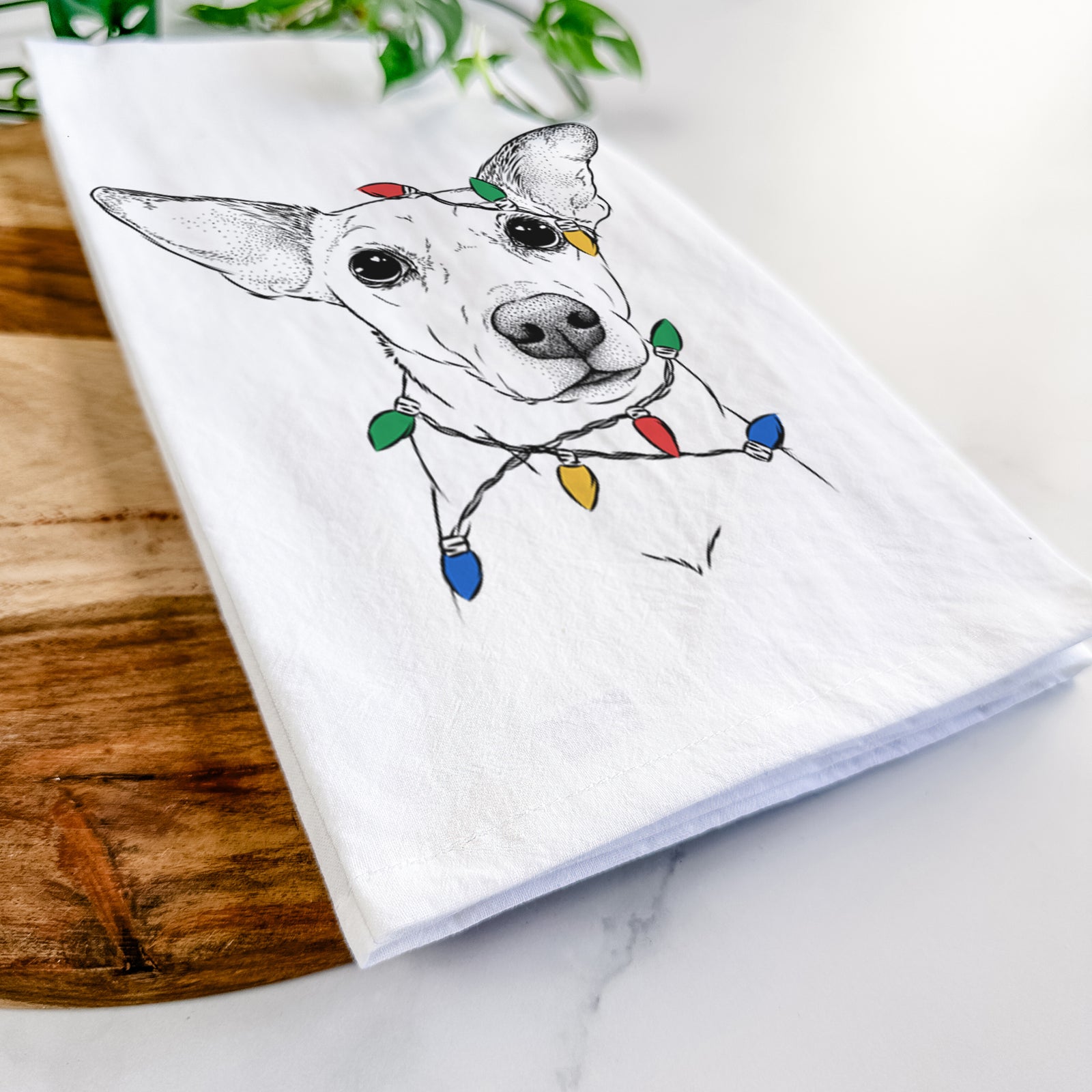 Hand-drawn sketch of Molly the Jack Russell Terrier wrapped in Christmas lights on a tea towel