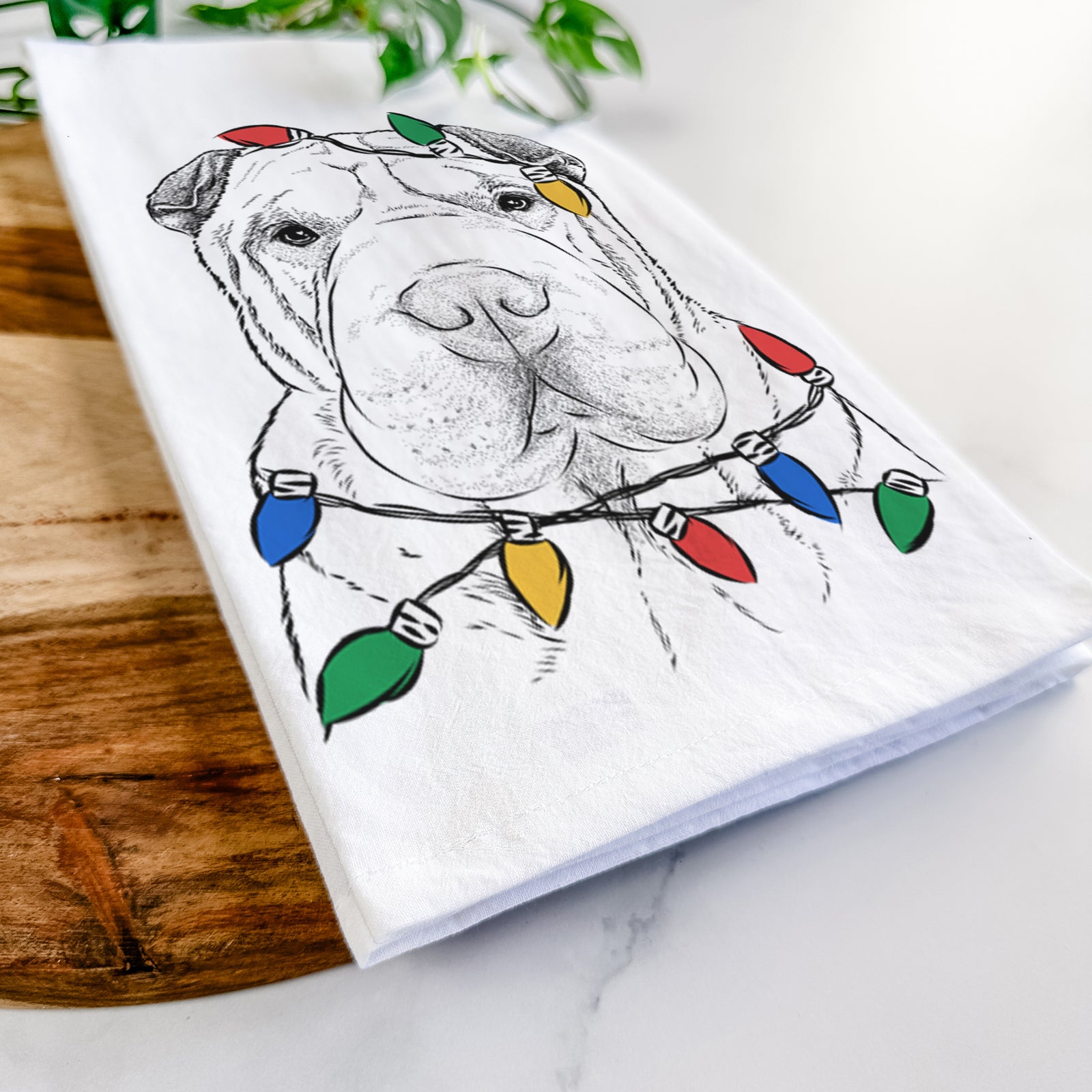 Hand-drawn sketch of Moomers the Shar Pei wrapped in Christmas lights on a tea towel