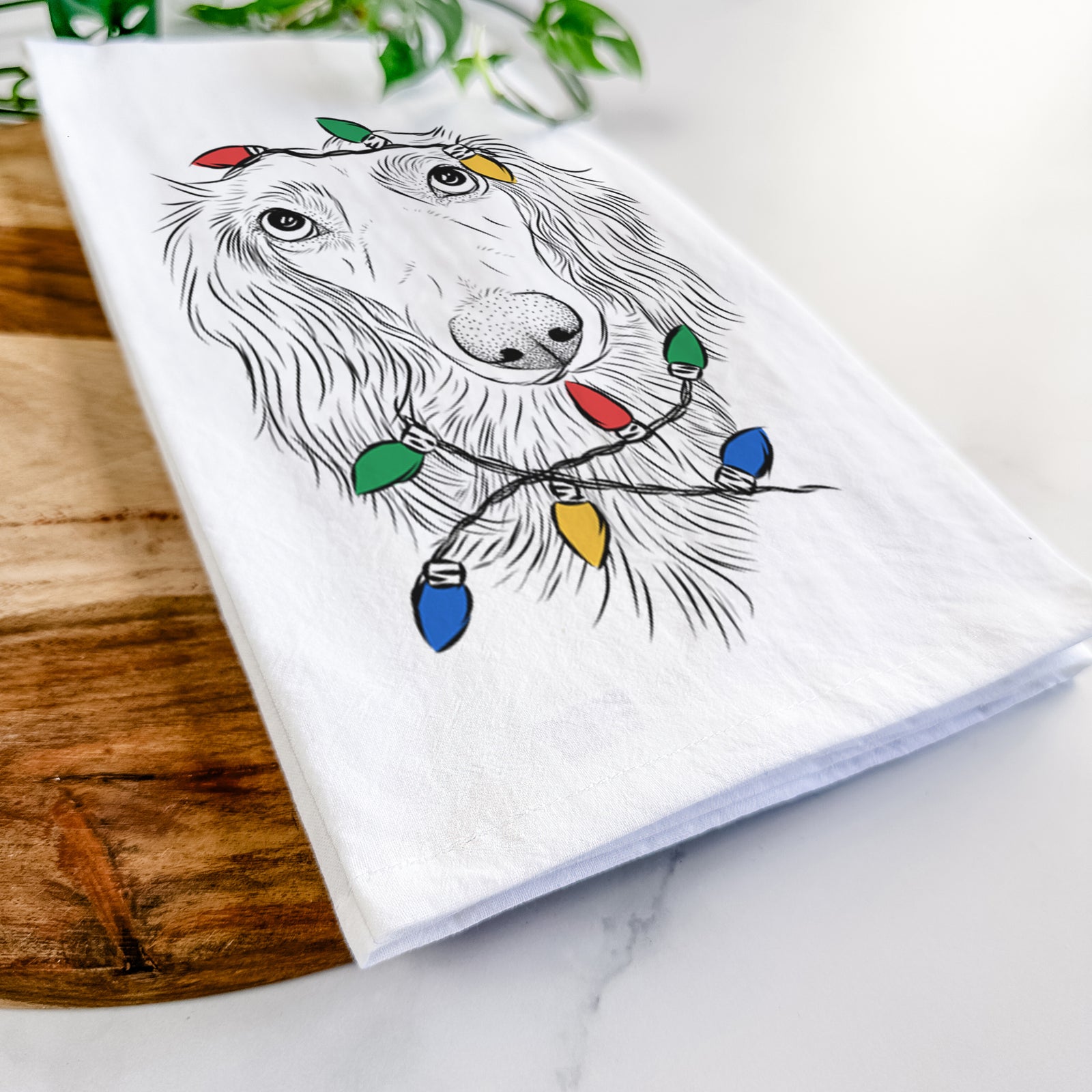 Hand-drawn sketch of Mr. Rusty the Long Haired Dachshund wrapped in Christmas lights on a tea towel