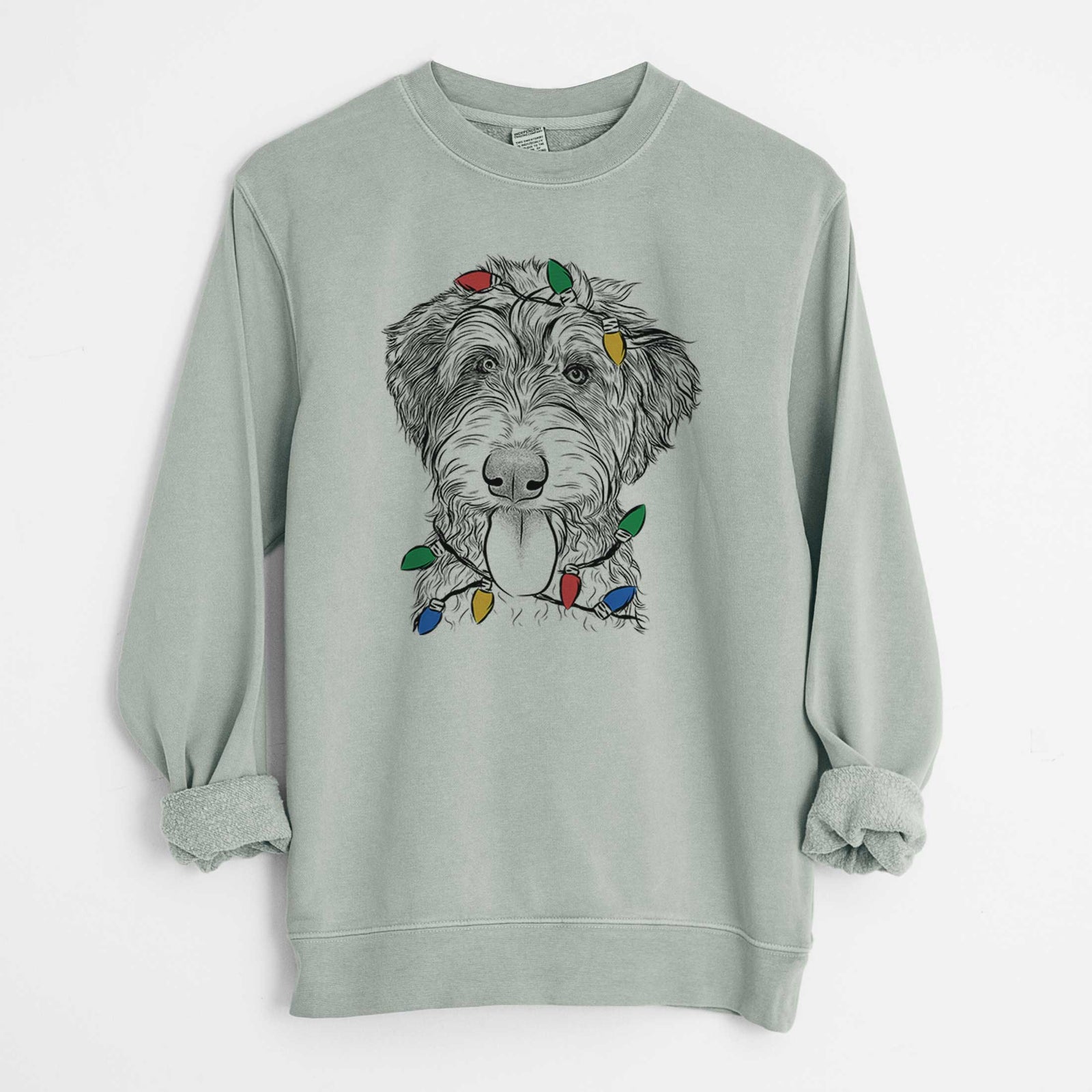 Hand-drawn sketch of Myrtle Mae the Aussiedoodle wrapped in Christmas lights on a Sage Unisex pigment dyed crew sweatshirt