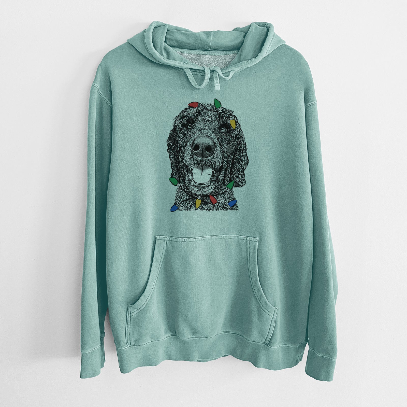 Hand-drawn sketch of Obi James the Goldendoodle wrapped in Christmas lights on a Mint Unisex pigment dyed hoodie