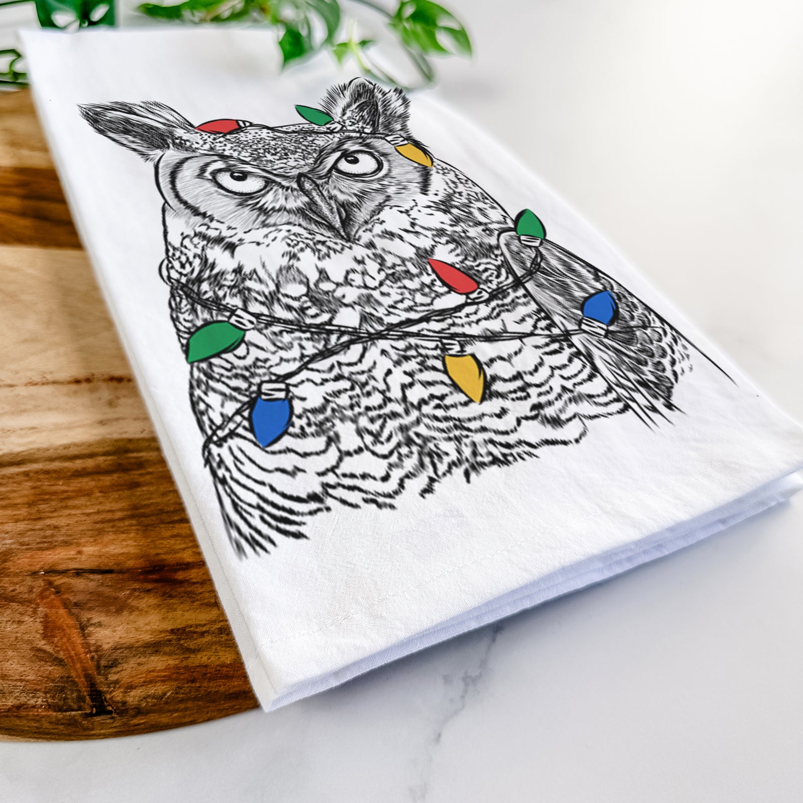 Hand-drawn sketch of Ozwald the Grey Horned Owl wrapped in Christmas lights on a tea towel