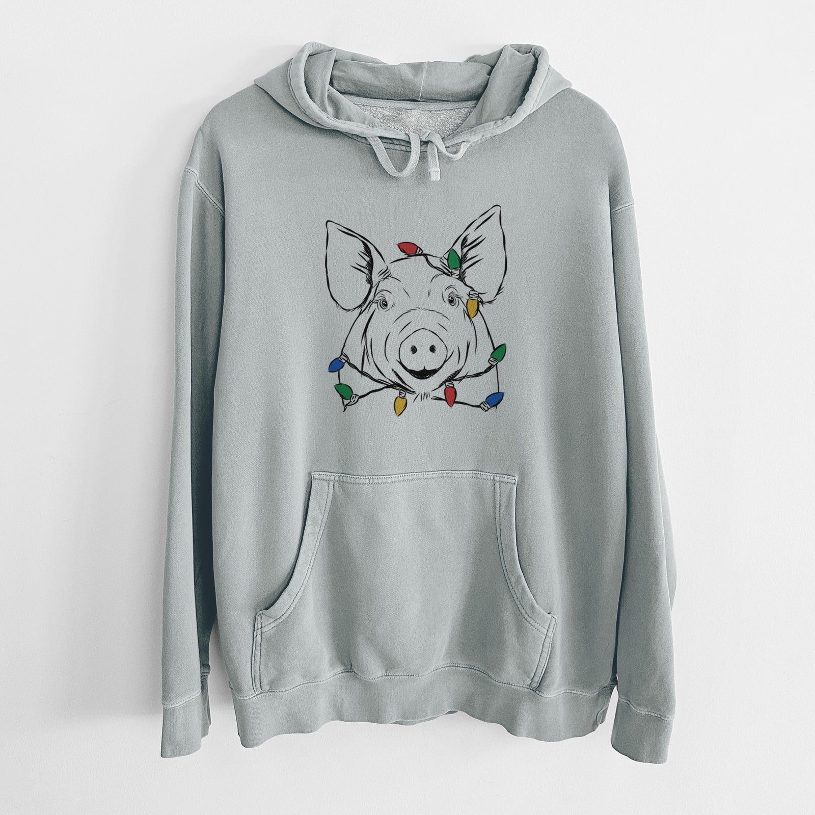 Hand-drawn sketch of Perry the Pig wrapped in Christmas lights on a Sage Unisex pigment dyed hoodie