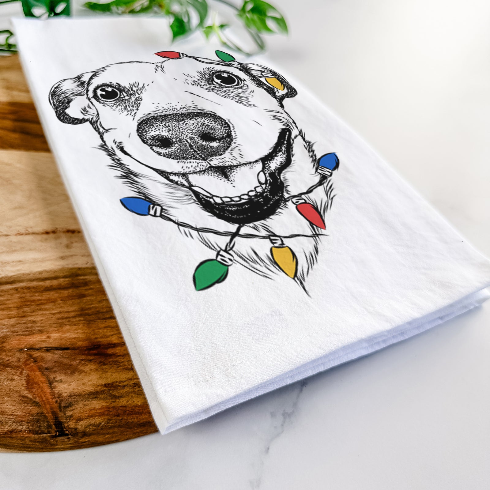 Hand-drawn sketch of Petrah the Staffy Mix wrapped in Christmas lights on a tea towel