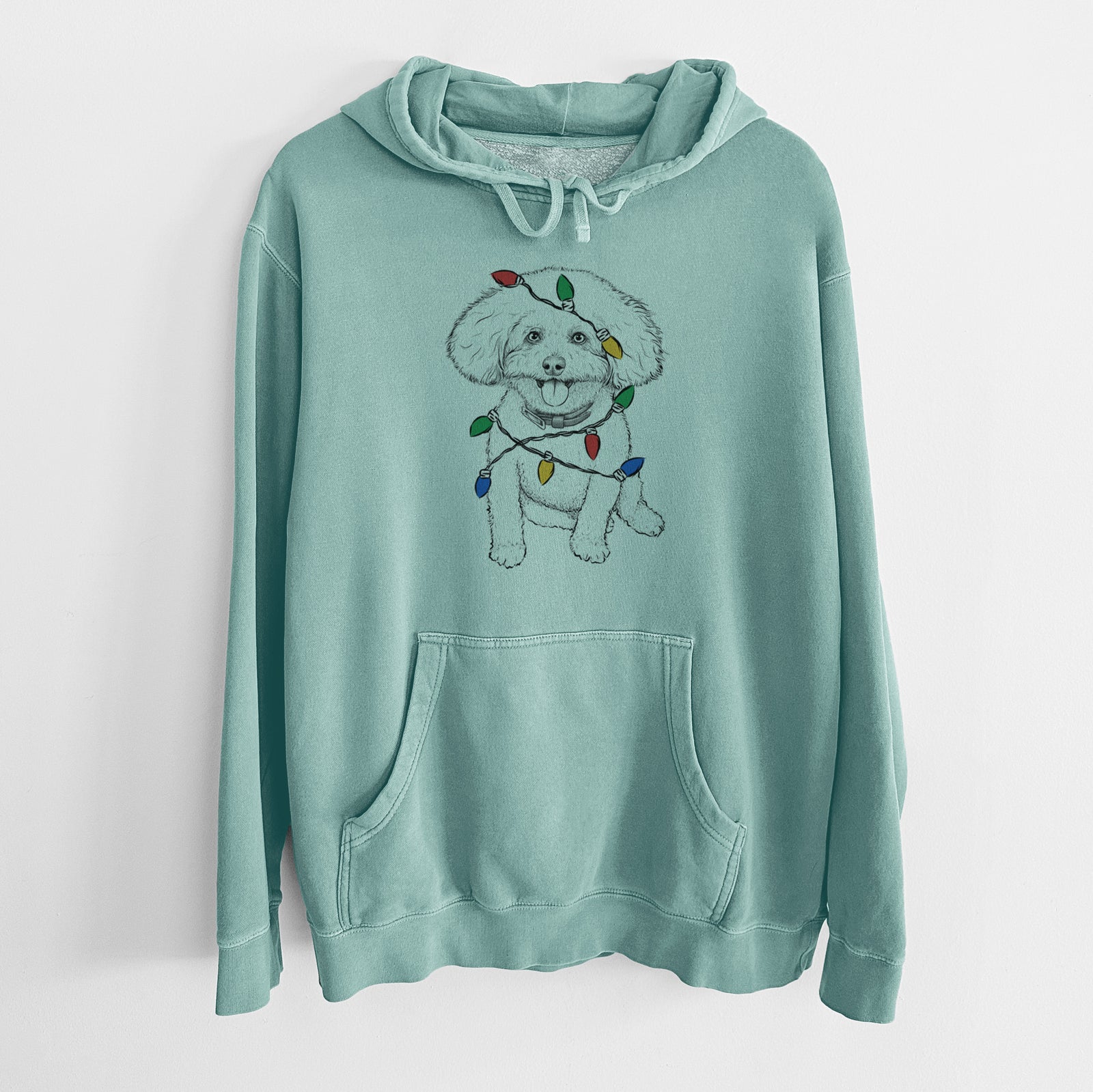 Hand-drawn sketch of Peyton the Bichon Frise wrapped in Christmas lights on a Mint Unisex pigment dyed hoodie