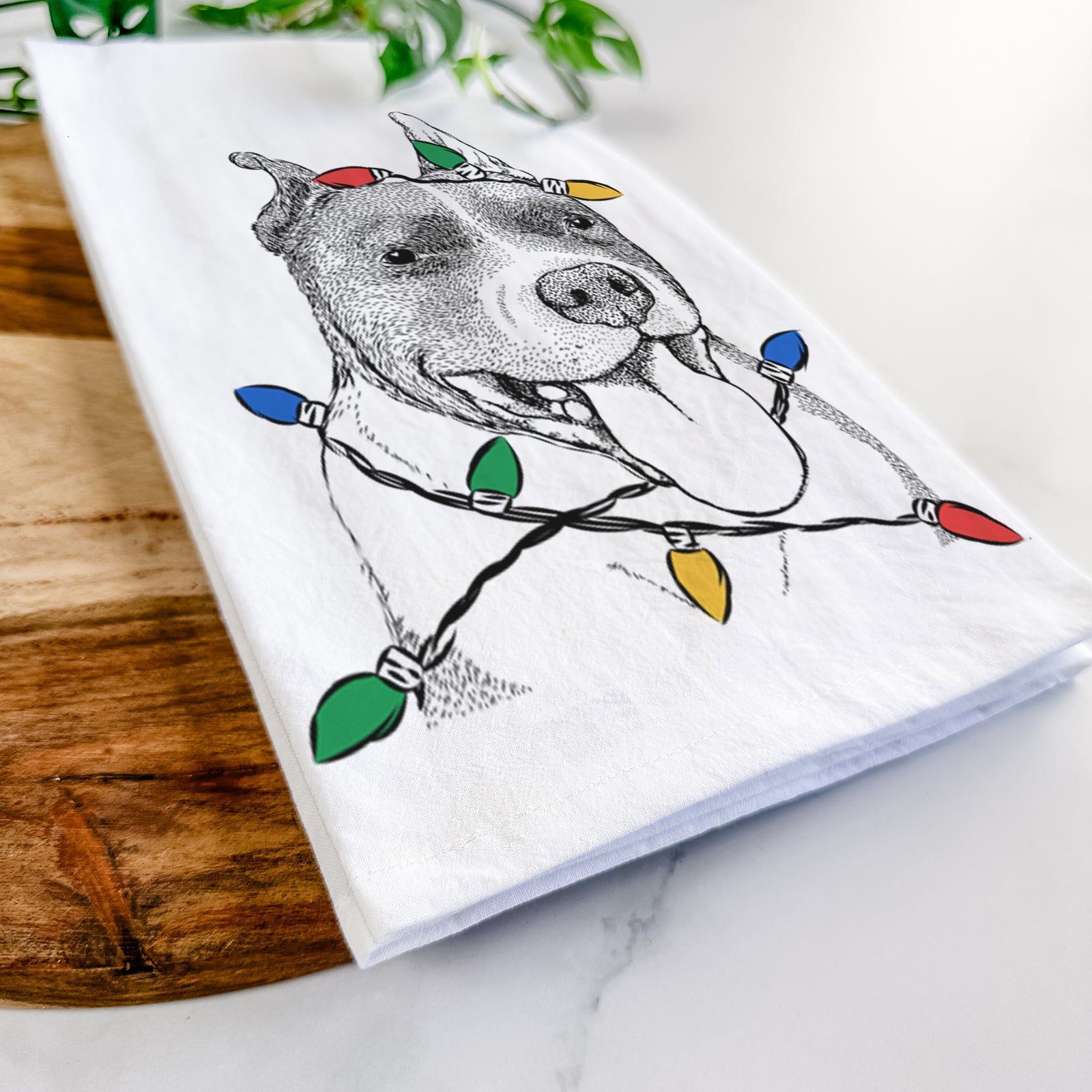 Hand-drawn sketch of Piggy the American Staffordshire Terrier wrapped in Christmas lights on a tea towel