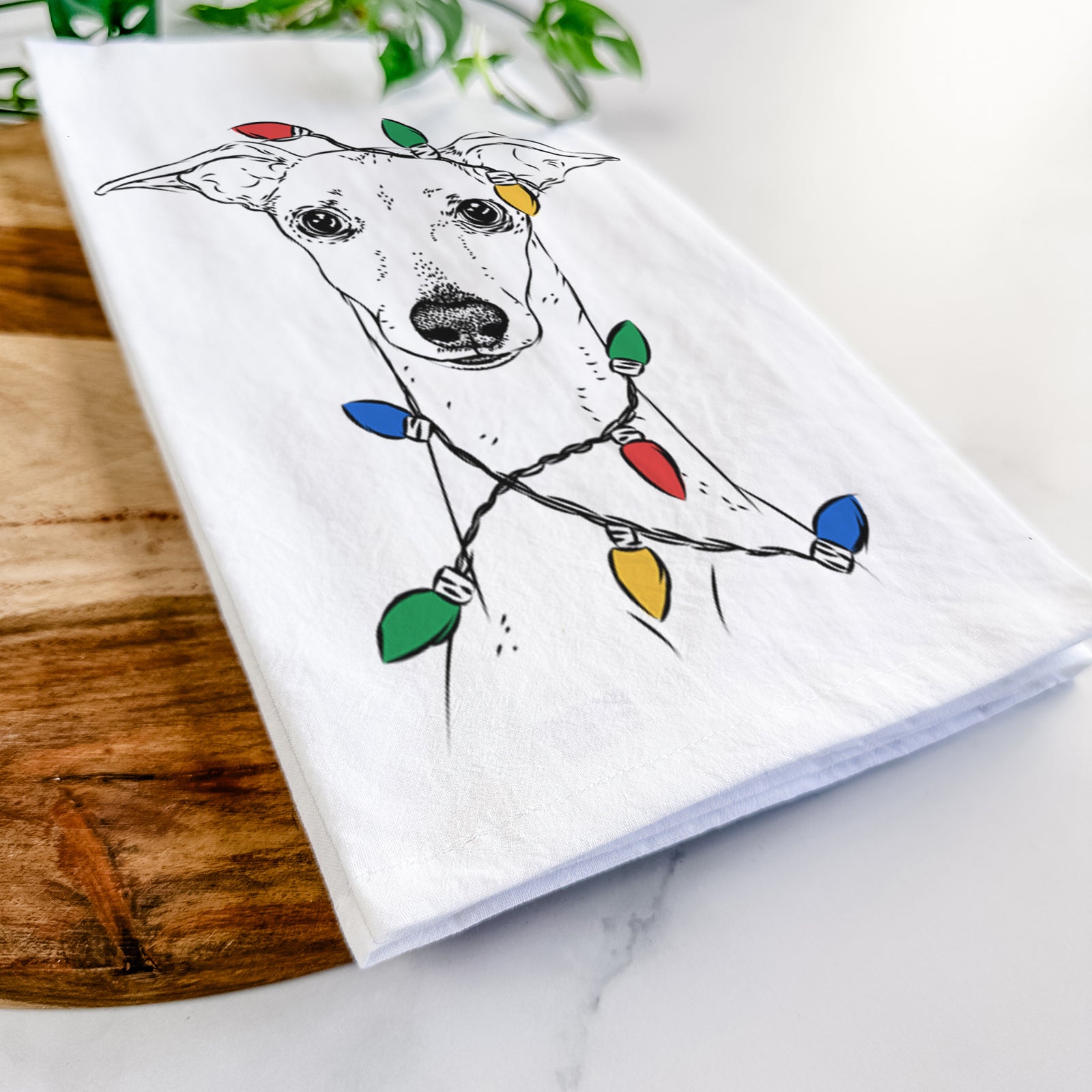 Hand-drawn sketch of Pip the Italian Greyhound wrapped in Christmas lights on a tea towel