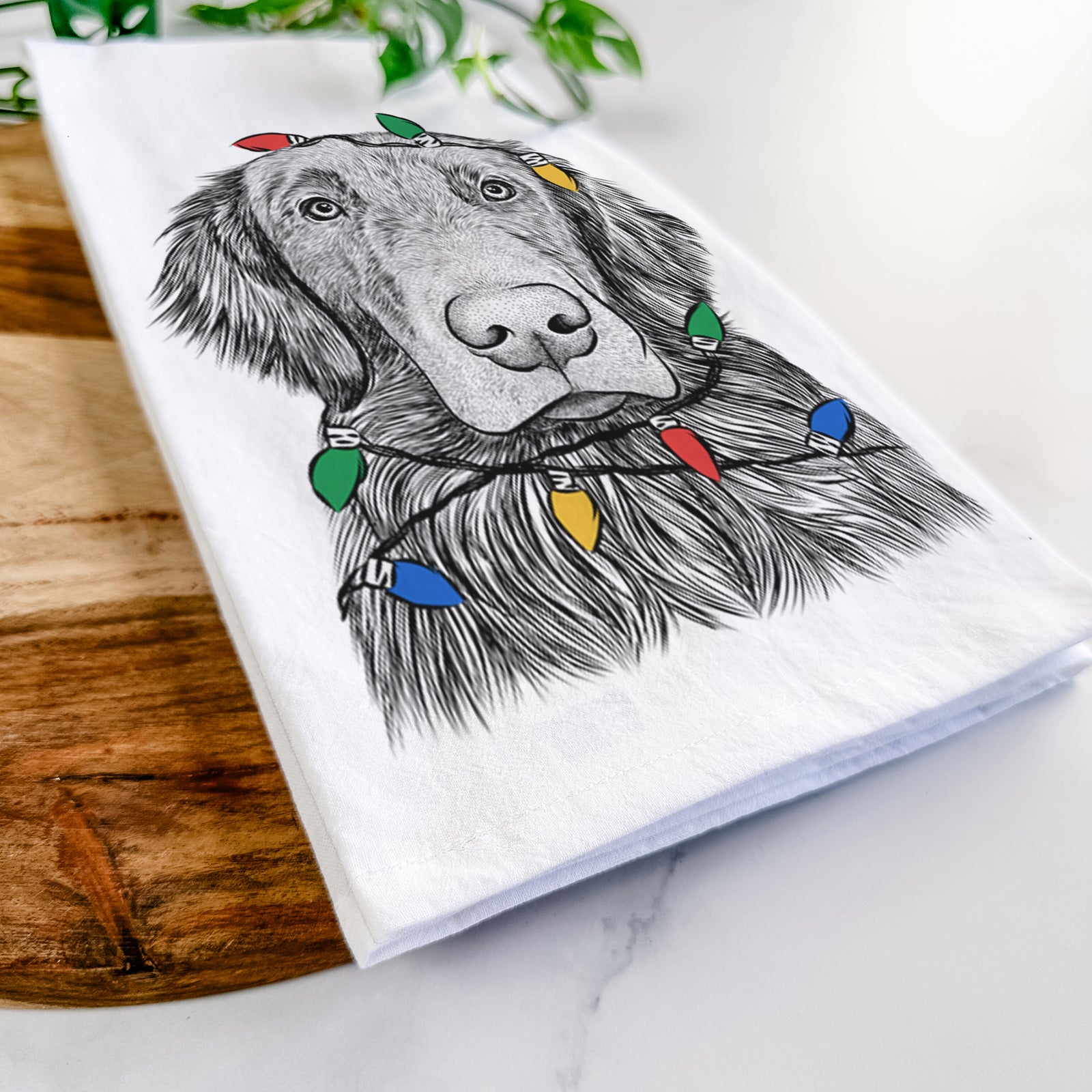 Hand-drawn sketch of Pippin the Flat Coated Retriever wrapped in Christmas lights on a tea towel