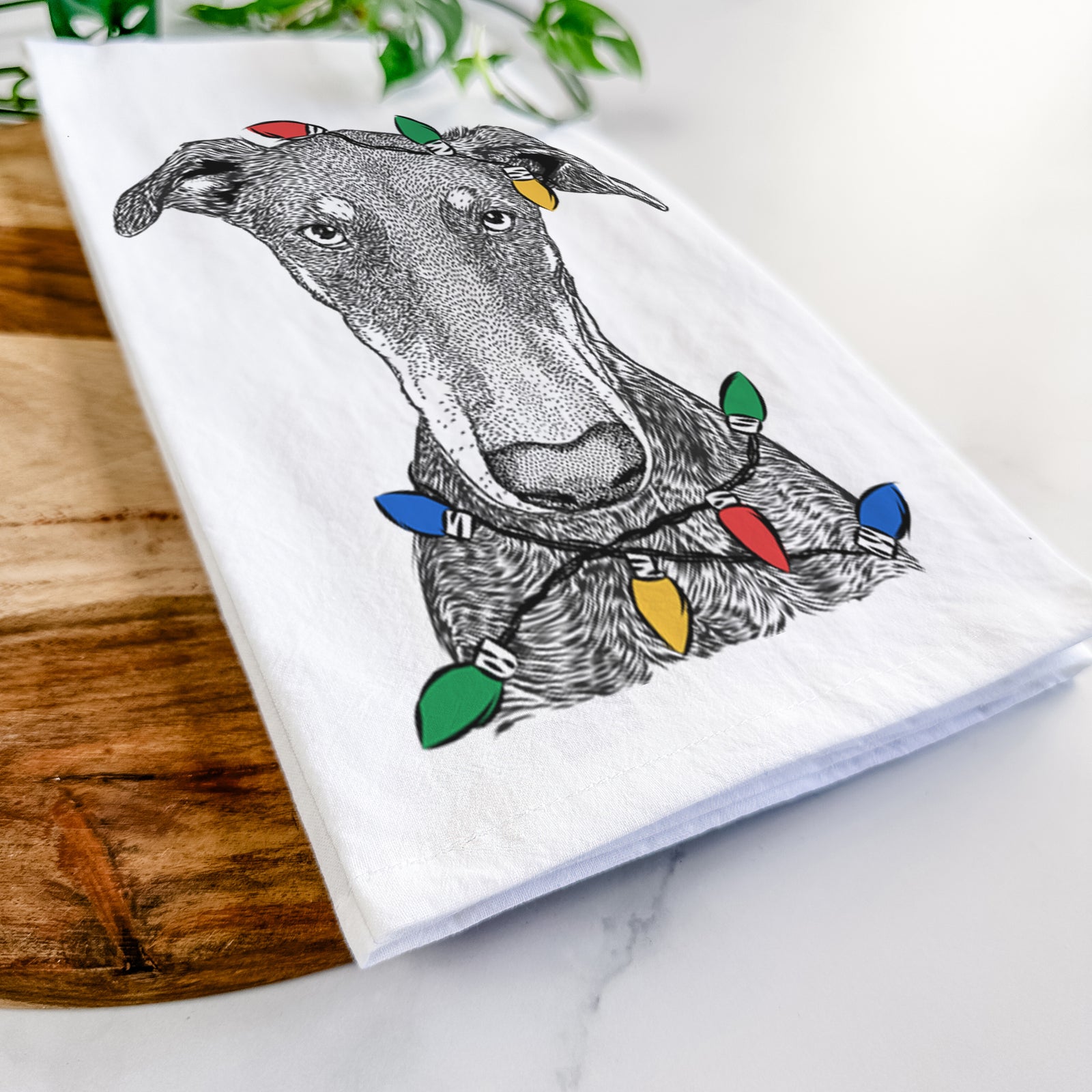 Hand-drawn sketch of Princess Fiona the Doberman Pinscher wrapped in Christmas lights on a tea towel