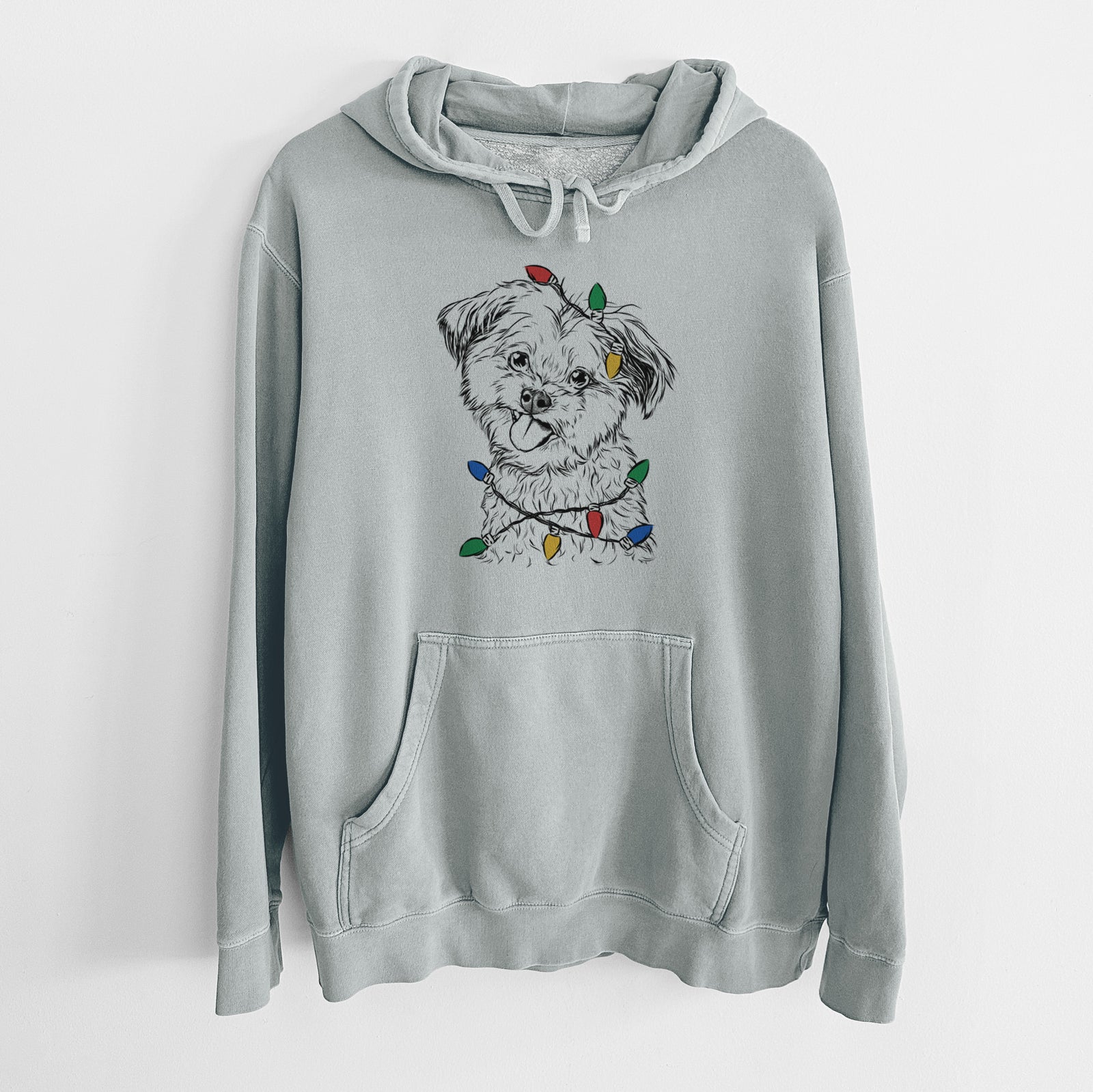 Hand-drawn sketch of Puff the Malshi wrapped in Christmas lights on a Sage Unisex pigment dyed hoodie