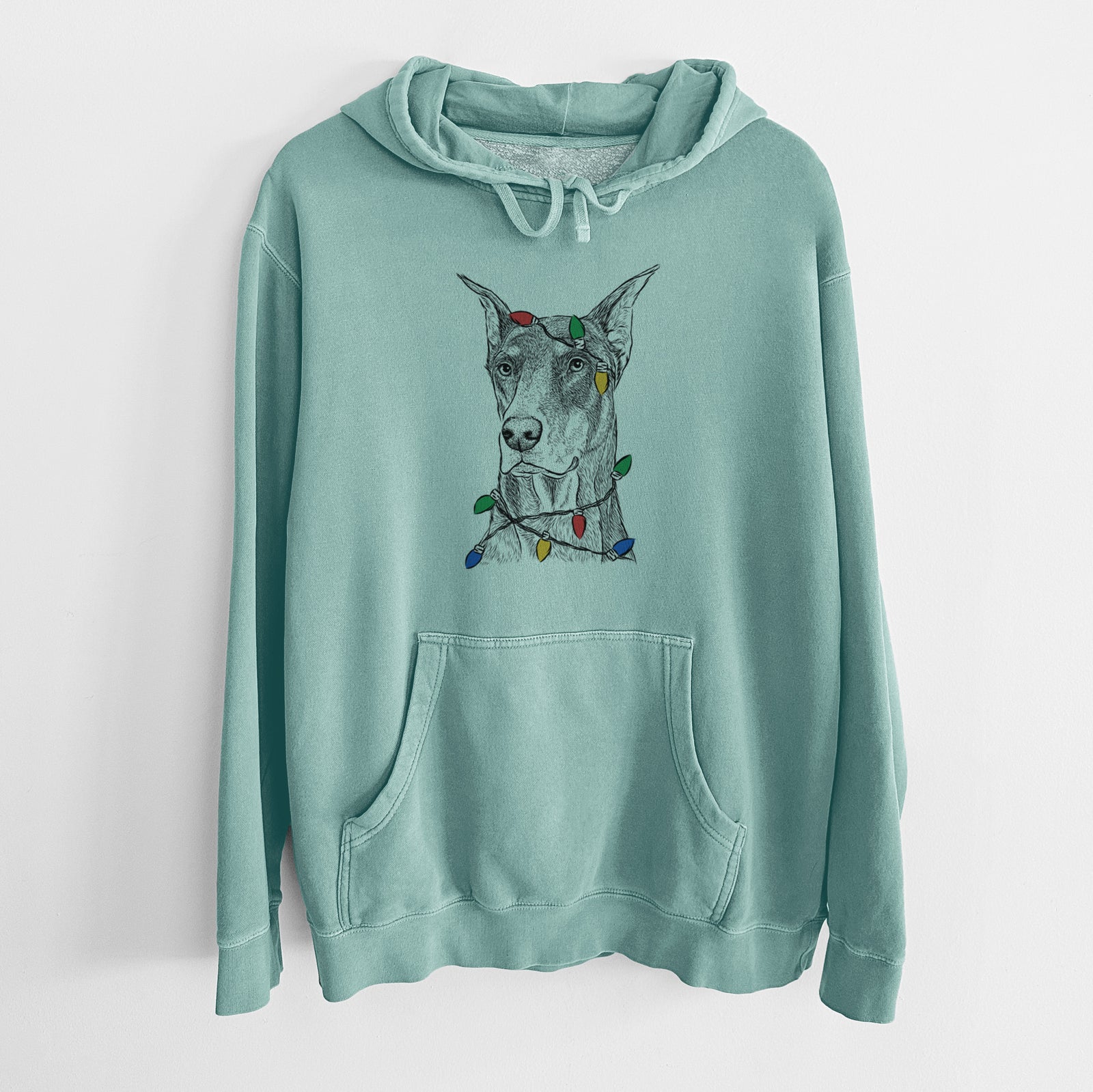 Hand-drawn sketch of RJ the Doberman Pinscher wrapped in Christmas lights on a Mint Unisex pigment dyed hoodie