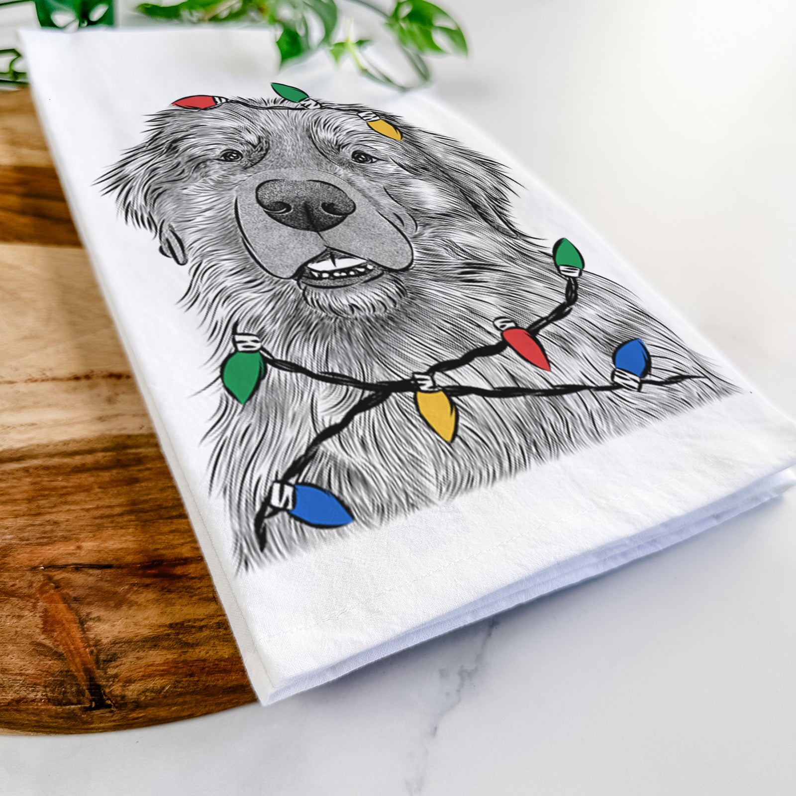 Hand-drawn sketch of Ralph the Leonberger wrapped in Christmas lights on a tea towel