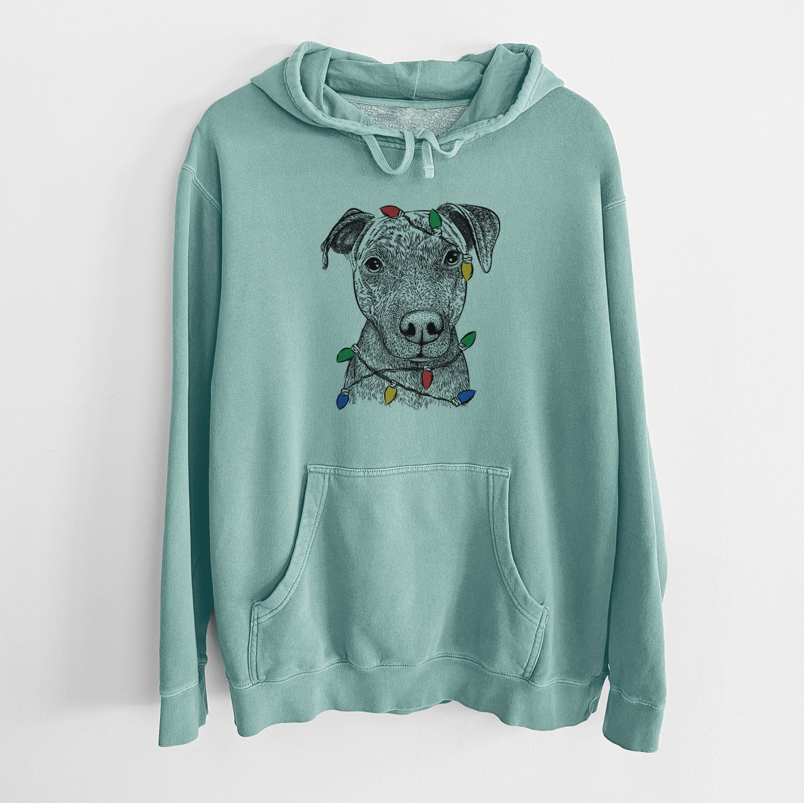 Hand-drawn sketch of Reeses the Pitbull wrapped in Christmas lights on a Mint Unisex pigment dyed hoodie