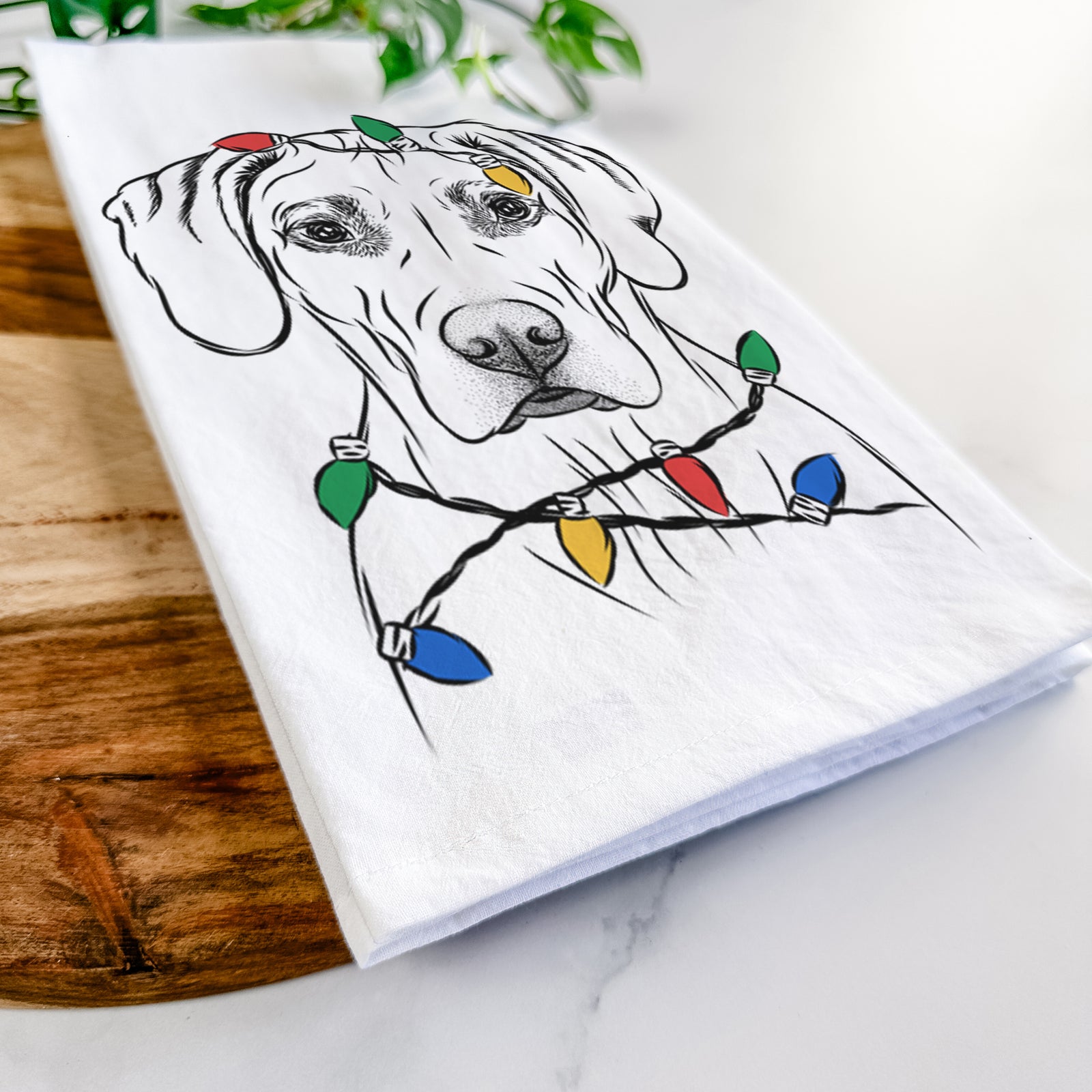 Hand-drawn sketch of Reid the Rhodesian Ridgeback wrapped in Christmas lights on a tea towel