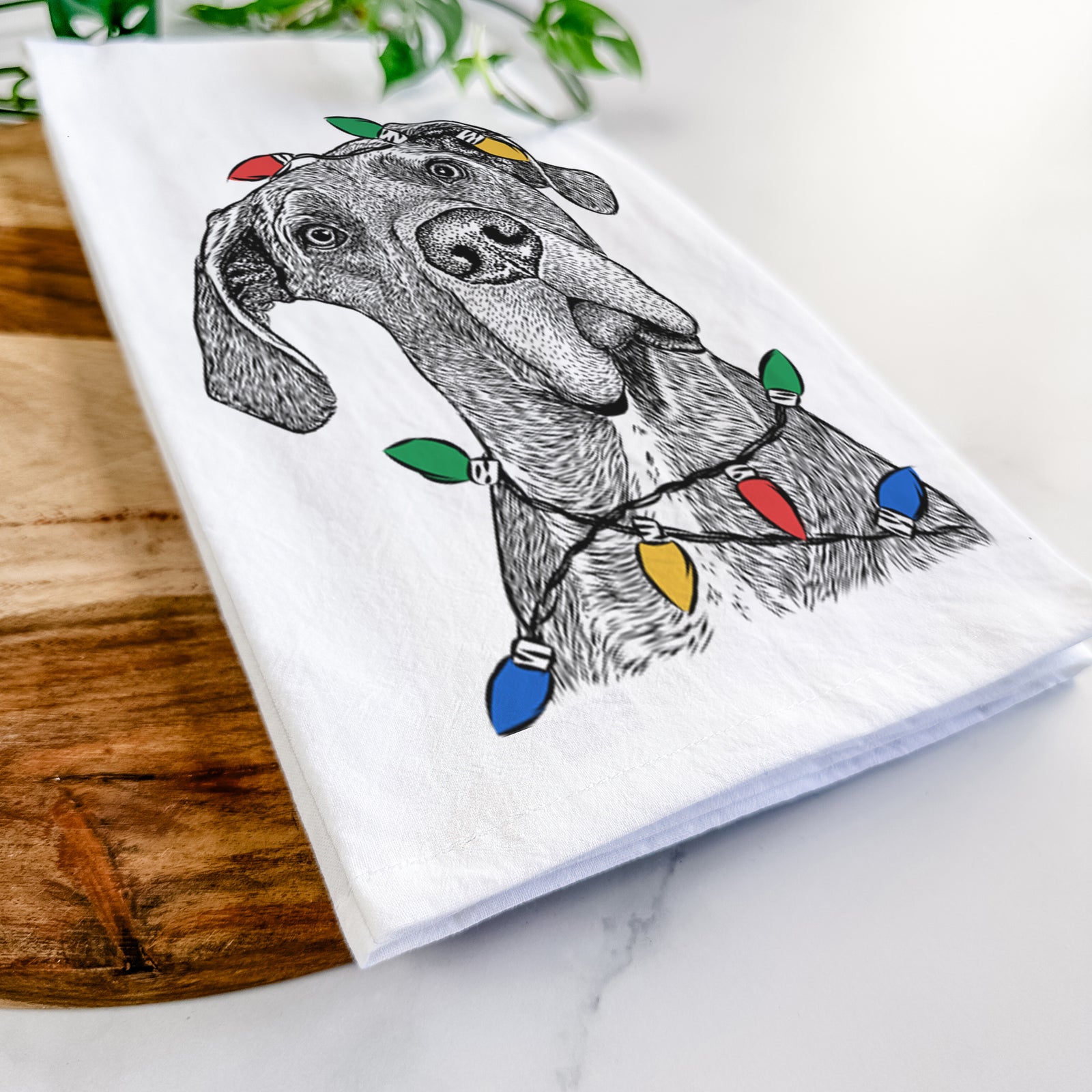 Hand-drawn sketch of River the Great Dane wrapped in Christmas lights on a tea towel