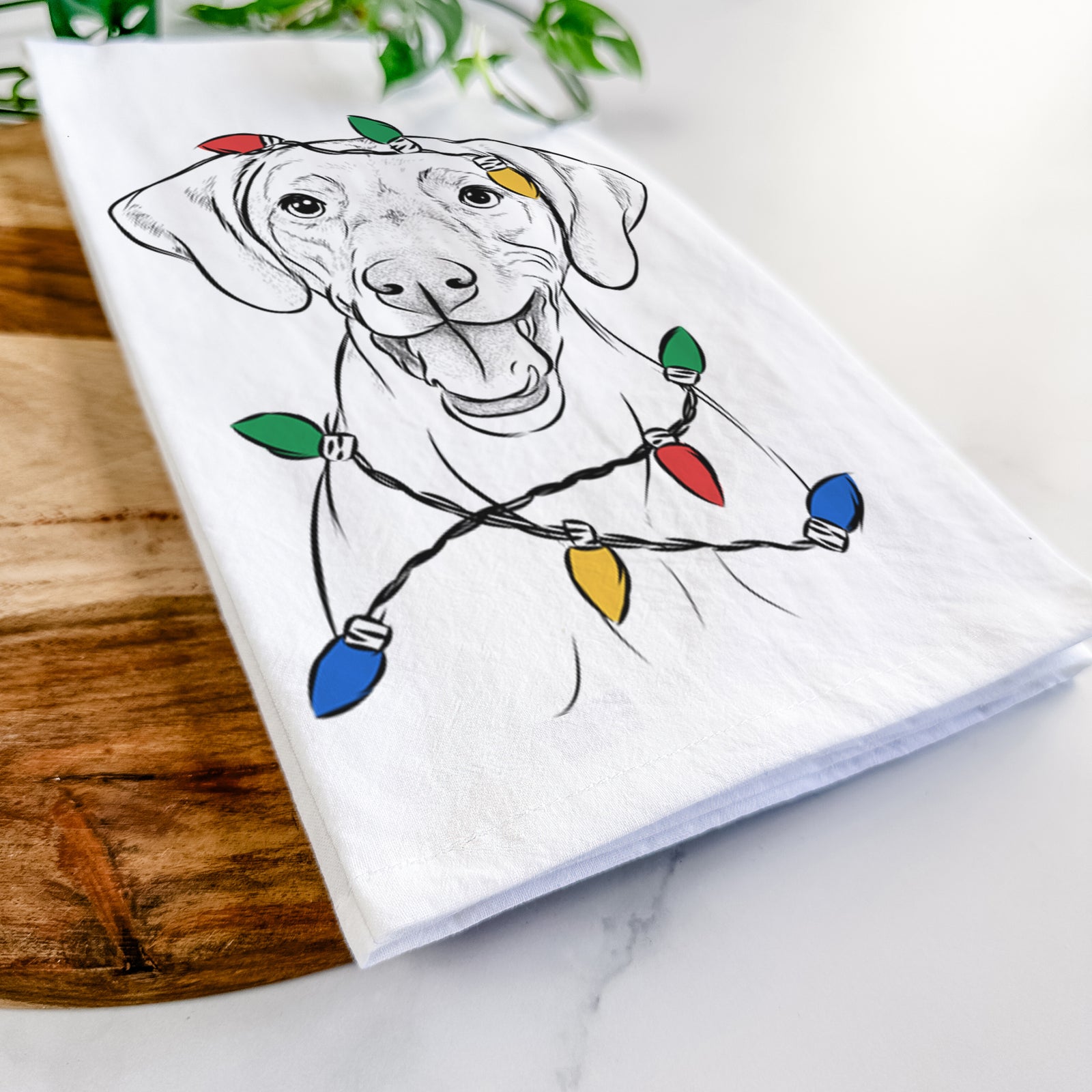 Hand-drawn sketch of Ruby the Vizsla wrapped in Christmas lights on a tea towel