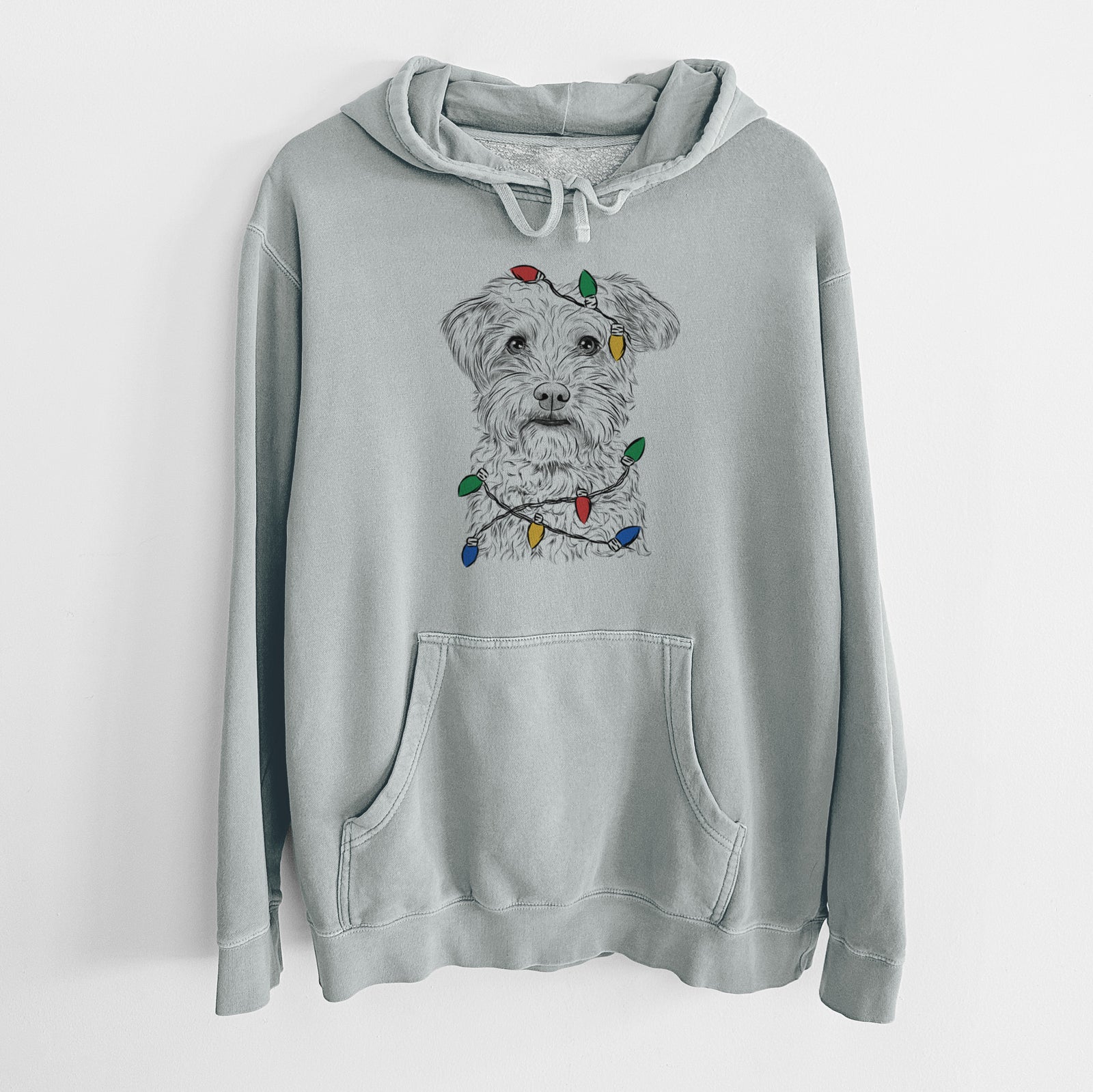 Hand-drawn sketch of Rudy the Schnoodle wrapped in Christmas lights on a Sage Unisex pigment dyed hoodie
